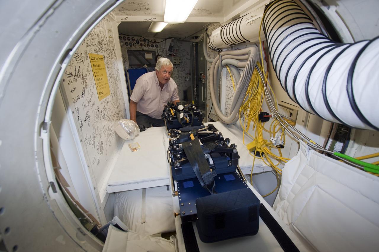 A technician moves mission specialist seats into space shuttle Atlantis as the spacecraft is prepared for public display. The work is taking place as Atlantis sits inside Orbiter Processing Facility-1 at NASA's Kennedy Space Center in Florida. Photo credit: NASA/Dmitri Gerondidakis