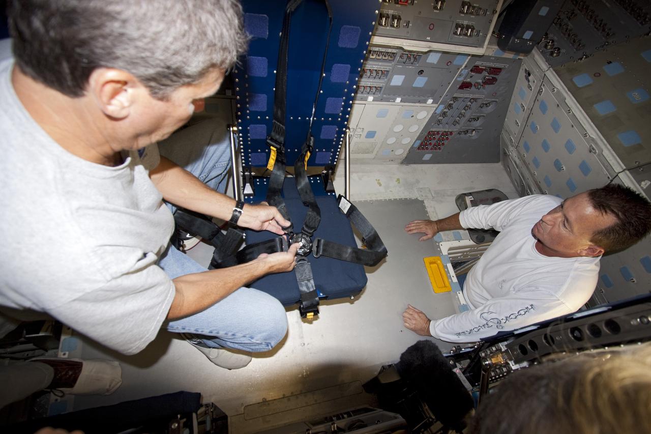 Technicians move mission specialist seat into place inside space shuttle Atlantis as the spacecraft is prepared for public display. The work is taking place as Atlantis sits inside Orbiter Processing Facility-1 at NASA's Kennedy Space Center in Florida. Photo credit: NASA/Dmitri Gerondidakis