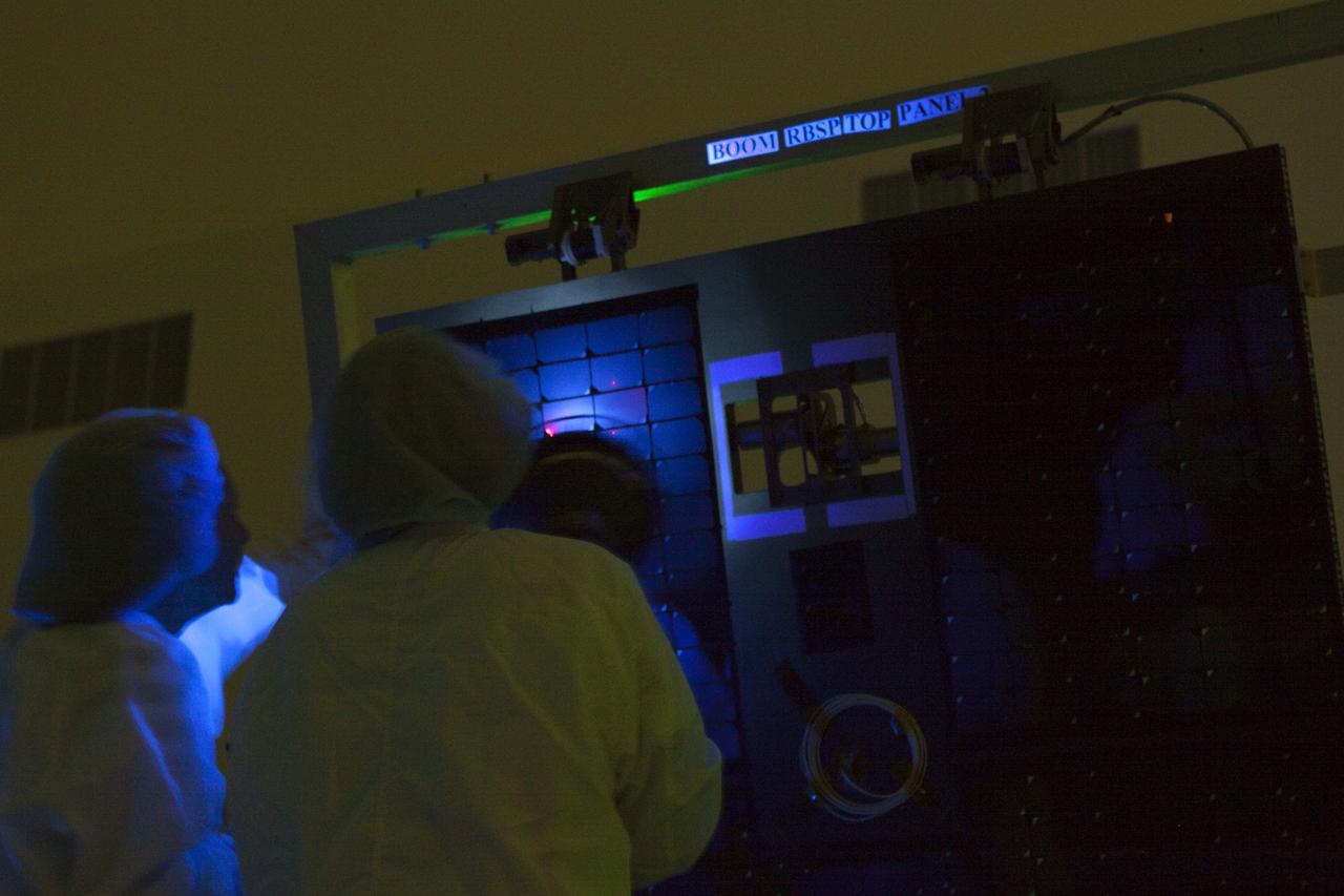 CAPE CANAVERAL, Fla. – Using a black light, technicians closely inspect a solar panel on one of NASA's twin Radiation Belt Storm Probes inside the clean room high bay at the Astrotech payload processing facility near NASA’s Kennedy Space Center in Florida. The technicians are dressed in clean-room attire known as “bunny suits.”    Black-light inspection uses UVA fluorescence to detect possible microcontamination, small cracks or fluid leaks. The Radiation Belt Storm Probes, or RBSP, mission will help us understand the sun’s influence on Earth and near-Earth space by studying the Earth’s radiation belts on various scales of space and time. RBSP will begin its mission of exploration of Earth's Van Allen radiation belts and the extremes of space weather after its launch aboard a United Launch Alliance Atlas V rocket. Launch is targeted for Aug. 23.   For more information, visit http://www.nasa.gov/rbsp.  Photo credit: NASA/Jim Grossmann