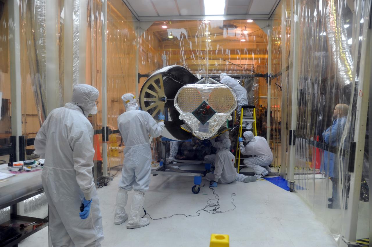 VANDENBERG AIR FORCE BASE, Calif. – In Orbital Sciences’ hangar on Vandenberg Air Force Base in California, technicians reinstall half of the Pegasus fairing around NASA’s Nuclear Spectroscopic Telescope Array, or NuSTAR, protected in an environmental enclosure.       Access to the spacecraft was needed for compatibility testing to verify communication with a tracking station in Hawaii. With the change in the launch timeframe to June, this station will be needed to support launch.  After processing of Orbital’s Pegasus XL rocket and the spacecraft is complete, they will be flown on Orbital's L-1011 carrier aircraft from Vandenberg, to the U.S. Army's Ronald Reagan Ballistic Missile Defense Test Site on Kwajalein Atoll, part of the Marshall Islands in the Pacific Ocean.  The Pegasus, mated to its NuSTAR payload, will be launched from the carrier aircraft 117 nautical miles south of Kwajalein at latitude 6.75 degrees north of the equator.  The high-energy X-ray telescope will conduct a census of black holes, map radioactive material in young supernovae remnants, and study the origins of cosmic rays and the extreme physics around collapsed stars. Launch is scheduled for June 13.  For more information, visit http://www.nasa.gov/nustar.  Photo credit: U.S. Air Force 30th Space Wing/Aaron Taubman, VAFB