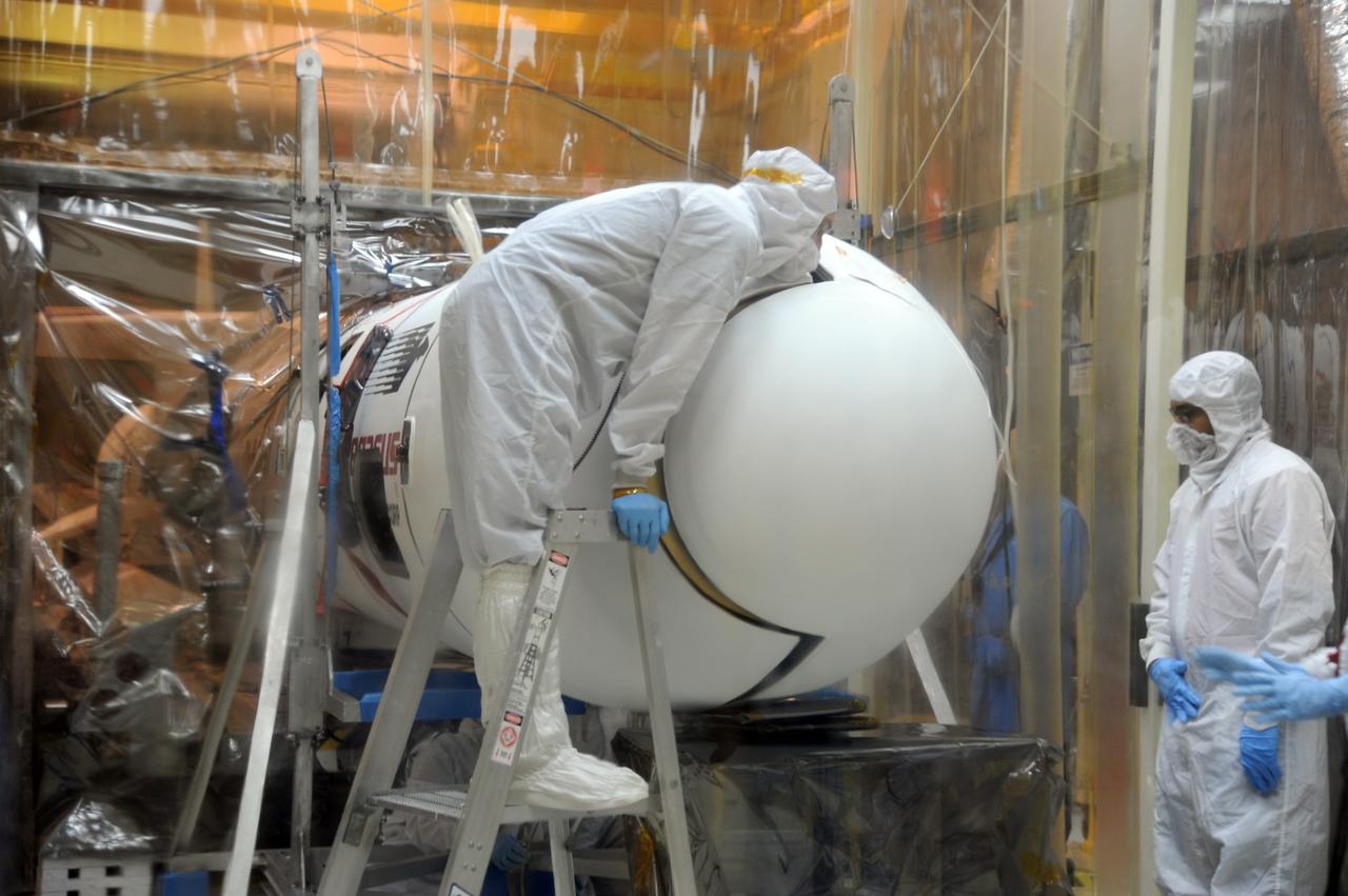 VANDENBERG AIR FORCE BASE, Calif. – In Orbital Sciences’ hangar on Vandenberg Air Force Base in California, a technician secures the Pegasus fairing around NASA’s Nuclear Spectroscopic Telescope Array, or NuSTAR.    Access to the spacecraft was needed for compatibility testing to verify communication with a tracking station in Hawaii. With the change in the launch timeframe to June, this station will be needed to support launch.  After processing of Orbital’s Pegasus XL rocket and the spacecraft is complete, they will be flown on Orbital's L-1011 carrier aircraft from Vandenberg, to the U.S. Army's Ronald Reagan Ballistic Missile Defense Test Site on Kwajalein Atoll, part of the Marshall Islands in the Pacific Ocean.  The Pegasus, mated to its NuSTAR payload, will be launched from the carrier aircraft 117 nautical miles south of Kwajalein at latitude 6.75 degrees north of the equator.  The high-energy X-ray telescope will conduct a census of black holes, map radioactive material in young supernovae remnants, and study the origins of cosmic rays and the extreme physics around collapsed stars. Launch is scheduled for June 13.  For more information, visit http://www.nasa.gov/nustar.  Photo credit: U.S. Air Force 30th Space Wing/Aaron Taubman, VAFB