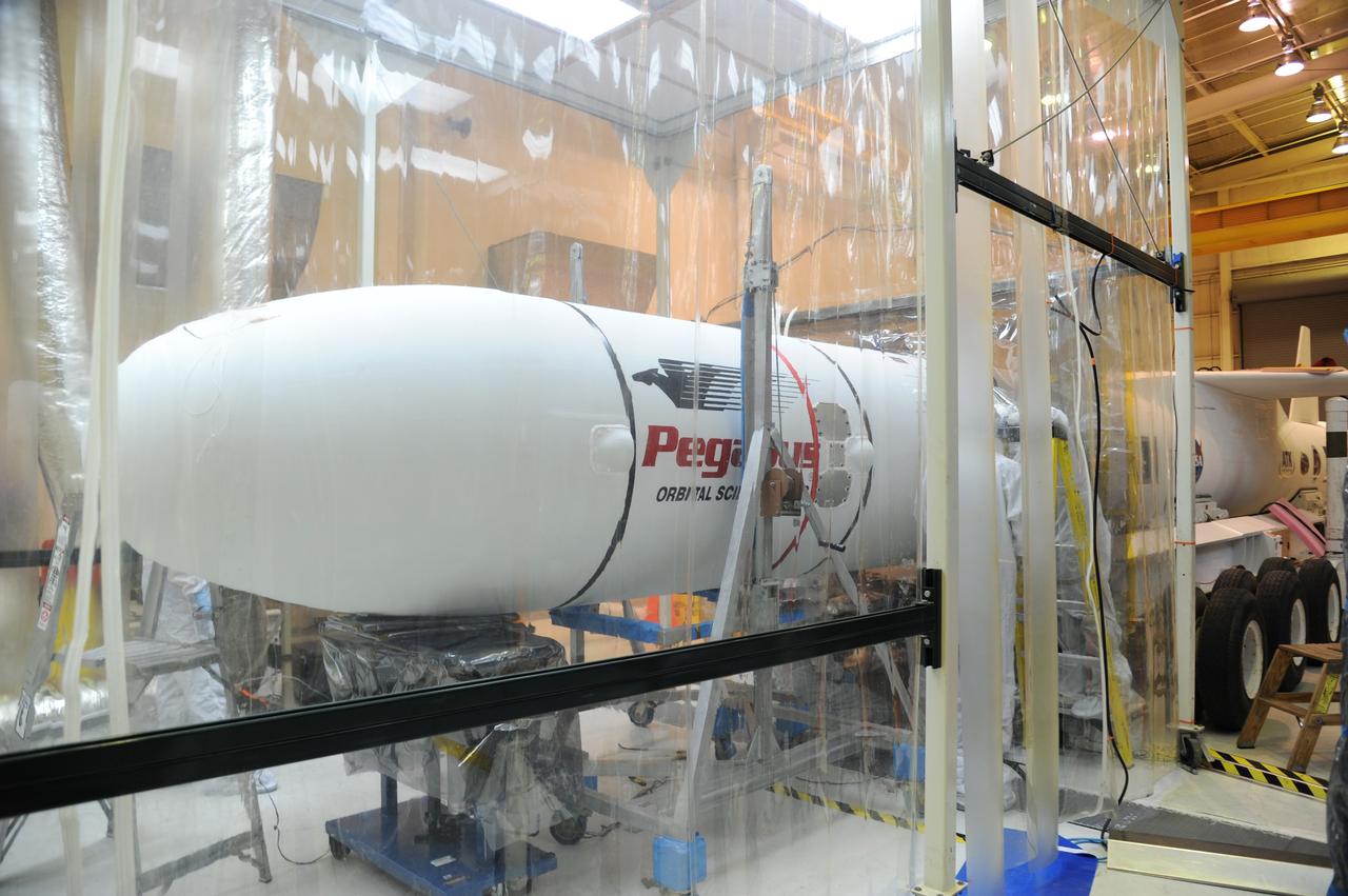 VANDENBERG AIR FORCE BASE, Calif. – In Orbital Sciences’ hangar on Vandenberg Air Force Base in California, the Pegasus fairing has been reinstalled around NASA’s Nuclear Spectroscopic Telescope Array, or NuSTAR.  NuSTAR is mated to Orbital’s Pegasus XL rocket, extending outside the environmental enclosure, at right.    Access to the spacecraft was needed for compatibility testing to verify communication with a tracking station in Hawaii. With the change in the launch timeframe to June, this station will be needed to support launch.  After processing of Orbital’s Pegasus XL rocket and the spacecraft is complete, they will be flown on Orbital's L-1011 carrier aircraft from Vandenberg, to the U.S. Army's Ronald Reagan Ballistic Missile Defense Test Site on Kwajalein Atoll, part of the Marshall Islands in the Pacific Ocean.  The Pegasus, mated to its NuSTAR payload, will be launched from the carrier aircraft 117 nautical miles south of Kwajalein at latitude 6.75 degrees north of the equator.  The high-energy X-ray telescope will conduct a census of black holes, map radioactive material in young supernovae remnants, and study the origins of cosmic rays and the extreme physics around collapsed stars. Launch is scheduled for June 13.  For more information, visit http://www.nasa.gov/nustar.  Photo credit: U.S. Air Force 30th Space Wing/Aaron Taubman, VAFB