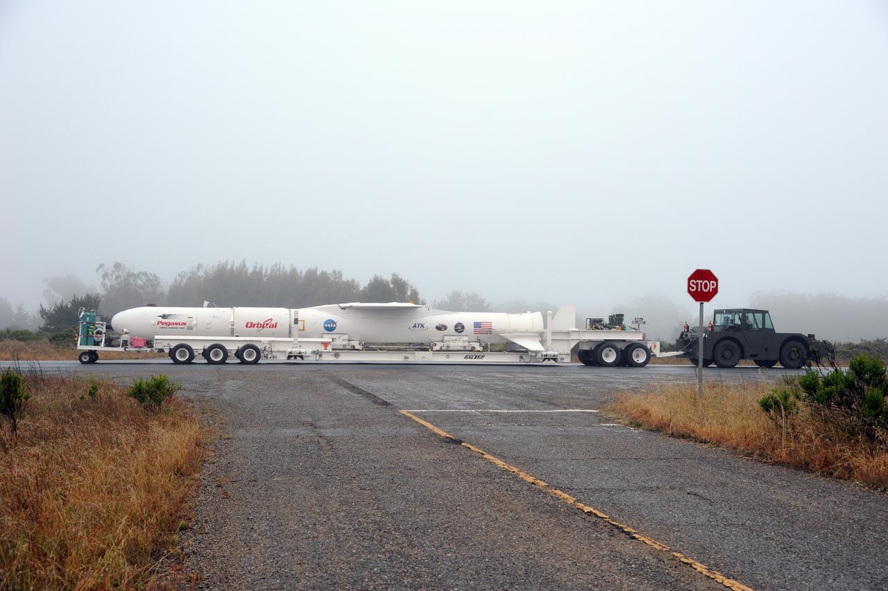 VANDENBERG AIR FORCE BASE, Calif. – NASA’s Nuclear Spectroscopic Telescope Array, or NuSTAR, mated to Orbital Sciences’ Pegasus XL rocket, travels along the roadway from Orbital’s processing hangar to the “hot pad,” located on the ramp adjacent to the runway on Vandenberg Air Force Base in California.  At the hot pad, the rocket will be attached beneath Orbital’s L-1011 carrier aircraft.    The duo will be flown from Vandenberg to the U.S. Army's Ronald Reagan Ballistic Missile Defense Test Site on Kwajalein Atoll, part of the Marshall Islands in the Pacific Ocean.  The Pegasus and its NuSTAR payload will be launched June 13 from the carrier aircraft 117 nautical miles south of Kwajalein at latitude 6.75 degrees north of the equator.  The high-energy X-ray telescope will conduct a census of black holes, map radioactive material in young supernovae remnants, and study the origins of cosmic rays and the extreme physics around collapsed stars. For more information, visit http://www.nasa.gov/nustar.  Photo credit: NASA/Chris Wiant, VAFB