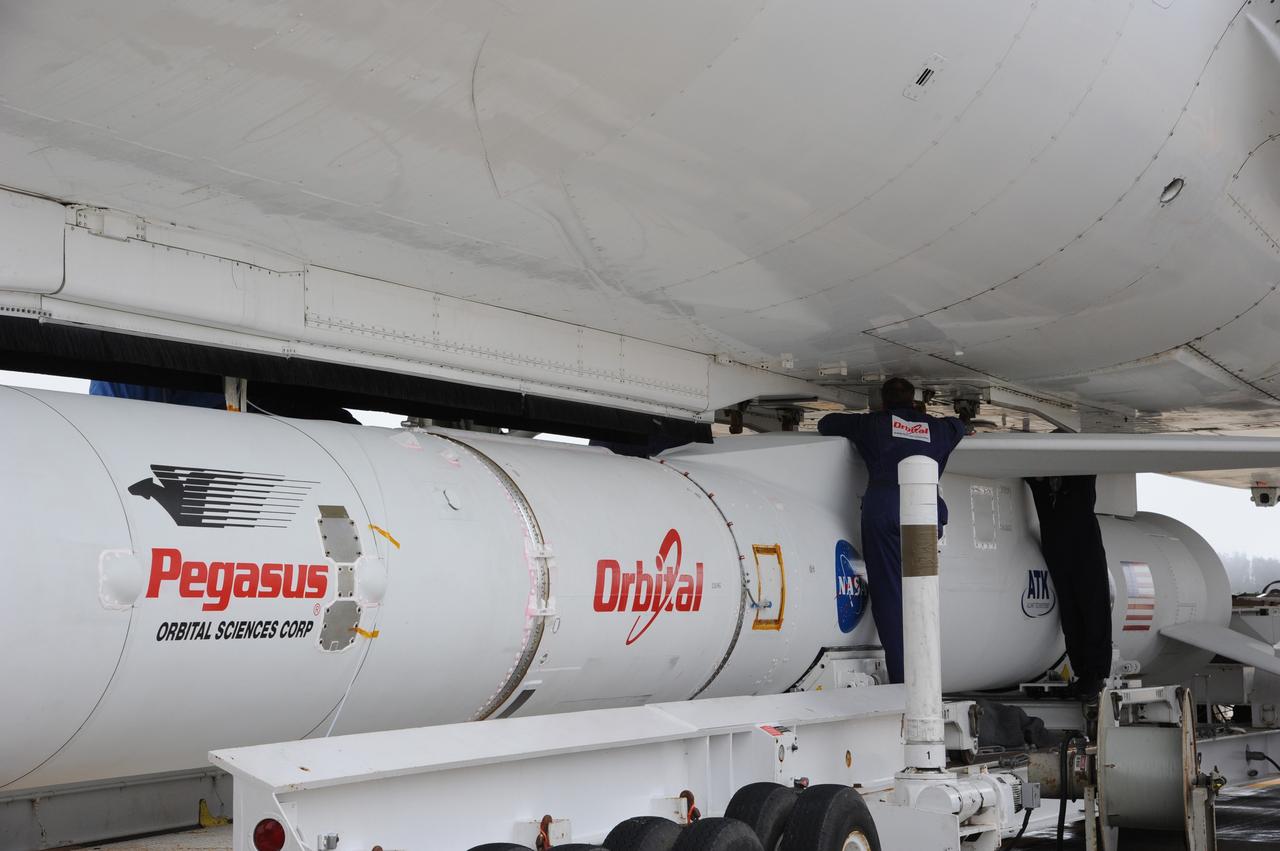 VANDENBERG AIR FORCE BASE, Calif. – Technicians attach NASA’s Nuclear Spectroscopic Telescope Array, or NuSTAR, mated to Orbital Sciences’ Pegasus XL rocket, beneath Orbital’s L-1011 carrier aircraft at the “hot pad,” located on the ramp adjacent to the runway on Vandenberg Air Force Base in California.    The duo will be flown from Vandenberg to the U.S. Army's Ronald Reagan Ballistic Missile Defense Test Site on Kwajalein Atoll, part of the Marshall Islands in the Pacific Ocean.  The Pegasus and its NuSTAR payload will be launched June 13 from the carrier aircraft 117 nautical miles south of Kwajalein at latitude 6.75 degrees north of the equator.  The high-energy X-ray telescope will conduct a census of black holes, map radioactive material in young supernovae remnants, and study the origins of cosmic rays and the extreme physics around collapsed stars. For more information, visit http://www.nasa.gov/nustar.  Photo credit: NASA/Chris Wiant, VAFB