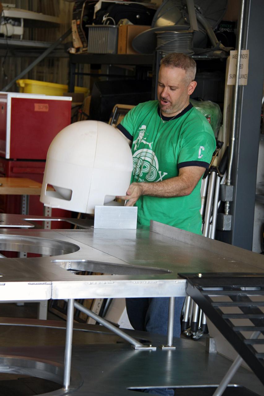 CAPE CANAVERAL, Fla. – NASA systems engineer Jim Smith assembles the prototype lander for NASA’s Regolith and Environment Science and Oxygen and Lunar Volatile Extraction, or RESOLVE, project in a test facility behind the Operations and Checkout Building at NASA’s Kennedy Space Center in Florida.    RESOLVE consists of a rover and drill provided by the Canadian Space Agency to support a NASA payload that is designed to prospect for water, ice and other lunar resources. RESOLVE also will demonstrate how future explorers can take advantage of resources at potential landing sites by manufacturing oxygen from soil. NASA will be conducting field tests in July outside of Hilo, Hawaii, with equipment and concept vehicles that demonstrate how explorers might prospect for resources and make their own oxygen for survival while on other planetary bodies.  For more information, visit http://www.nasa.gov/exploration/analogs/index.html.  Photo credit: NASA/Ben Smegelsky