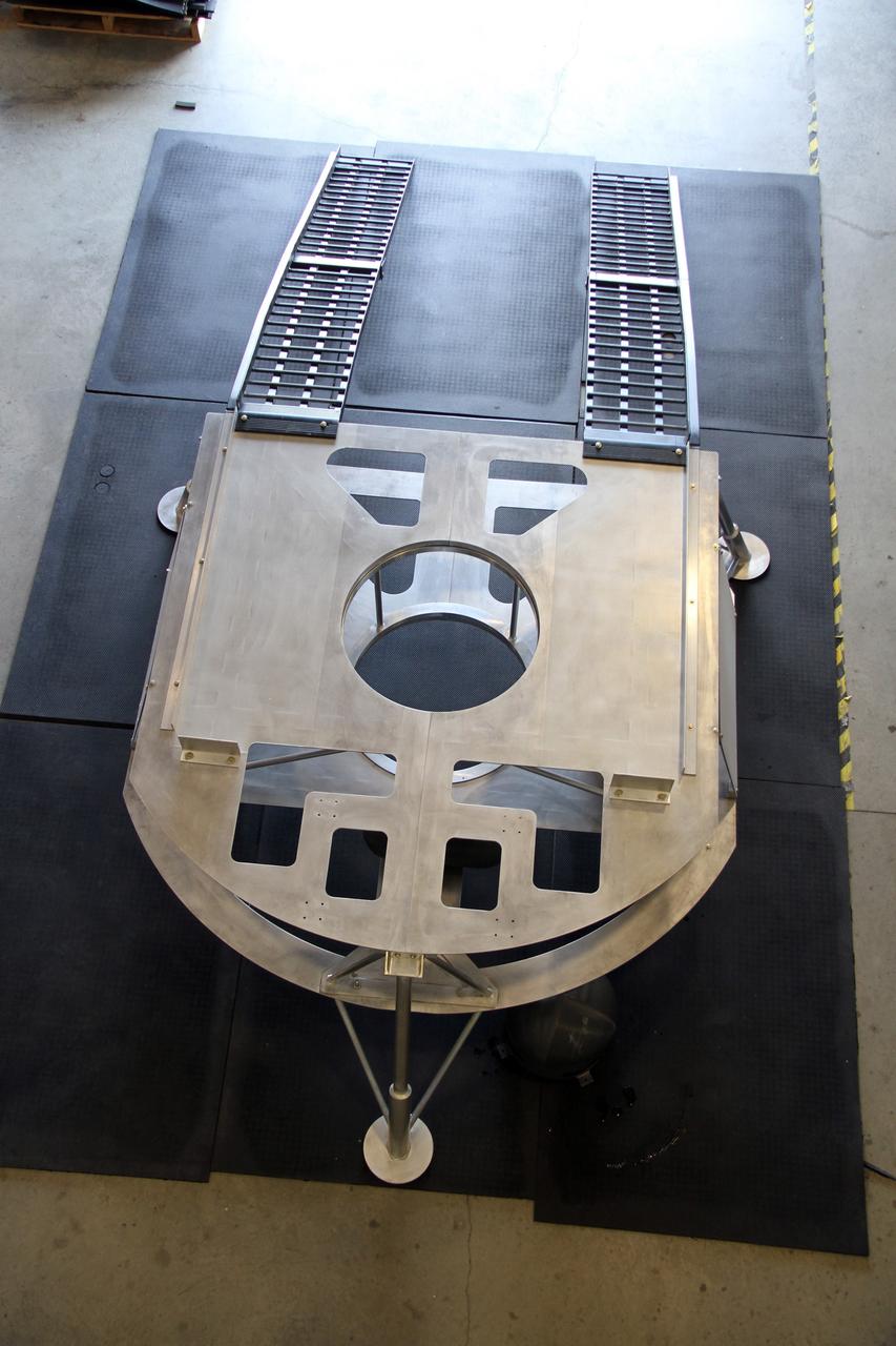 CAPE CANAVERAL, Fla. – This overhead view of the prototype lander for NASA’s Regolith and Environment Science and Oxygen and Lunar Volatile Extraction, or RESOLVE, project was taken in a test facility behind the Operations and Checkout Building at NASA’s Kennedy Space Center in Florida and reveals the lander’s unique structure and the placement of the ramps that will provide RESOLVE’s rover an avenue to mount or dismount the lander.     RESOLVE consists of a rover and drill provided by the Canadian Space Agency to support a NASA payload that is designed to prospect for water, ice and other lunar resources. RESOLVE also will demonstrate how future explorers can take advantage of resources at potential landing sites by manufacturing oxygen from soil. NASA will be conducting field tests in July outside of Hilo, Hawaii, with equipment and concept vehicles that demonstrate how explorers might prospect for resources and make their own oxygen for survival while on other planetary bodies.  For more information, visit http://www.nasa.gov/exploration/analogs/index.html.  Photo credit: NASA/Ben Smegelsky