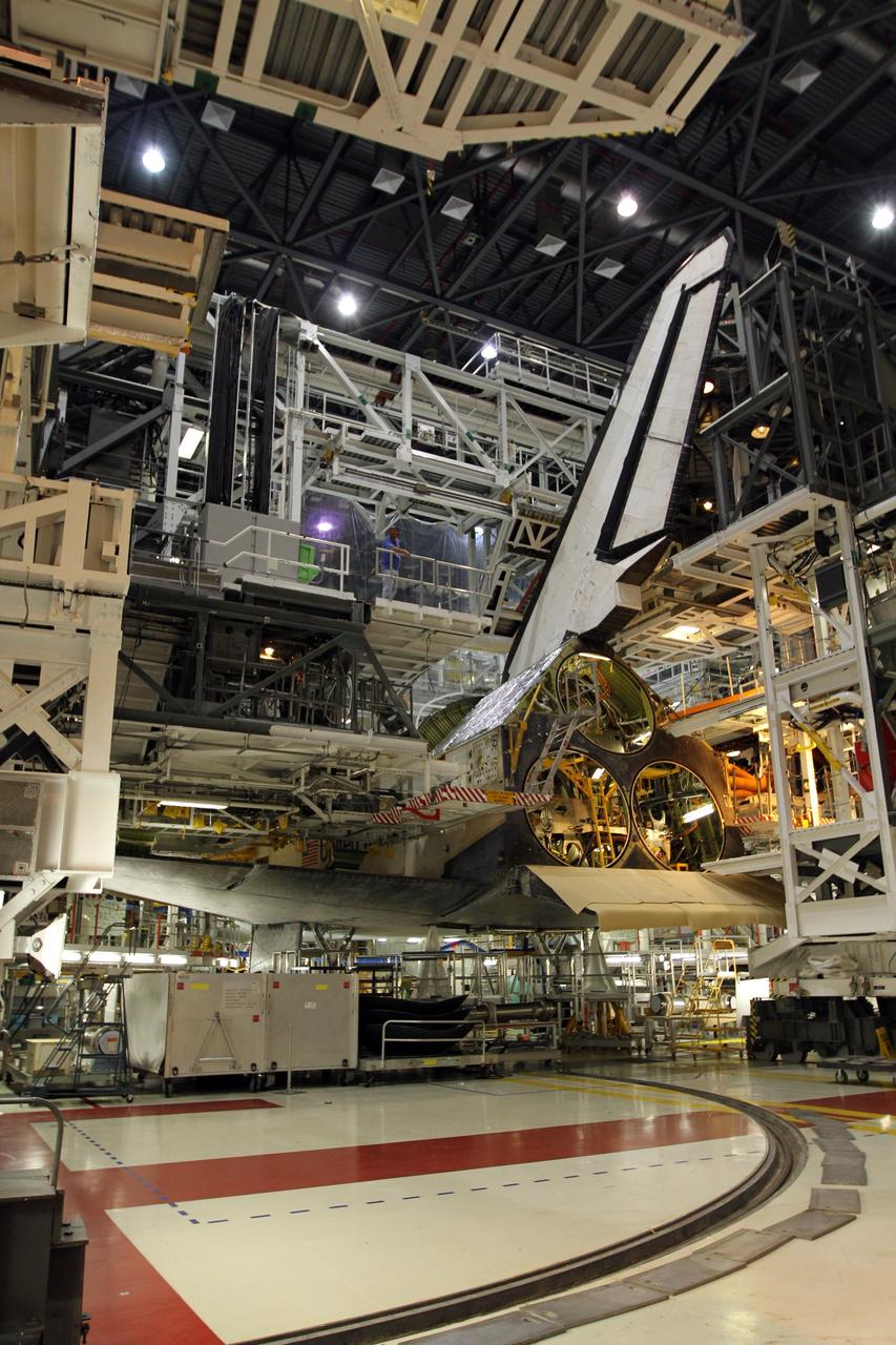 CAPE CANAVERAL, Fla. – The swing structure in Orbiter Processing Facility-1 moves from around the aft of space shuttle Atlantis so the orbital maneuvering system pod can be placed on the shuttle. The shuttle is being prepared for public display. Photo credit: NASA/Kim Shiflett