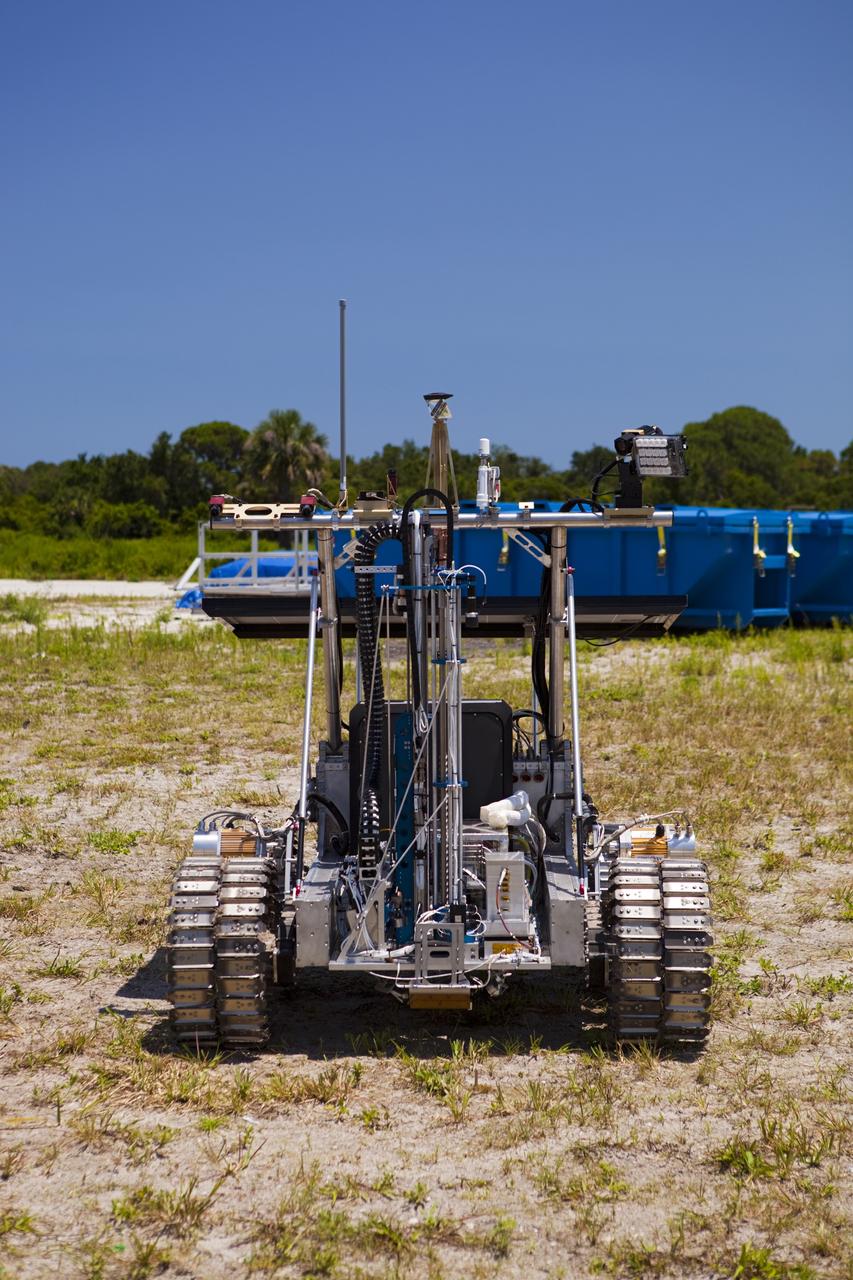CAPE CANAVERAL, Fla. – A demonstration of the prototype rover Artemis Jr. for NASA’s Regolith and Environment Science and Oxygen and Lunar Volatile Extraction, or RESOLVE, project is conducted in a field beside the Operations and Checkout Building at NASA’s Kennedy Space Center in Florida.      The rover and its drill are provided by the Canadian Space Agency and work in concert with NASA science instruments to prospect for water, ice and other lunar resources.  RESOLVE also will demonstrate how future explorers can take advantage of resources at potential landing sites by manufacturing oxygen from soil. NASA will conduct field tests in July outside of Hilo, Hawaii, with equipment and concept vehicles that demonstrate how explorers might prospect for resources and make their own oxygen for survival while on other planetary bodies.  For more information, visit http://www.nasa.gov/exploration/analogs/index.html.  Photo credit: NASA/Dimitri Gerondidakis