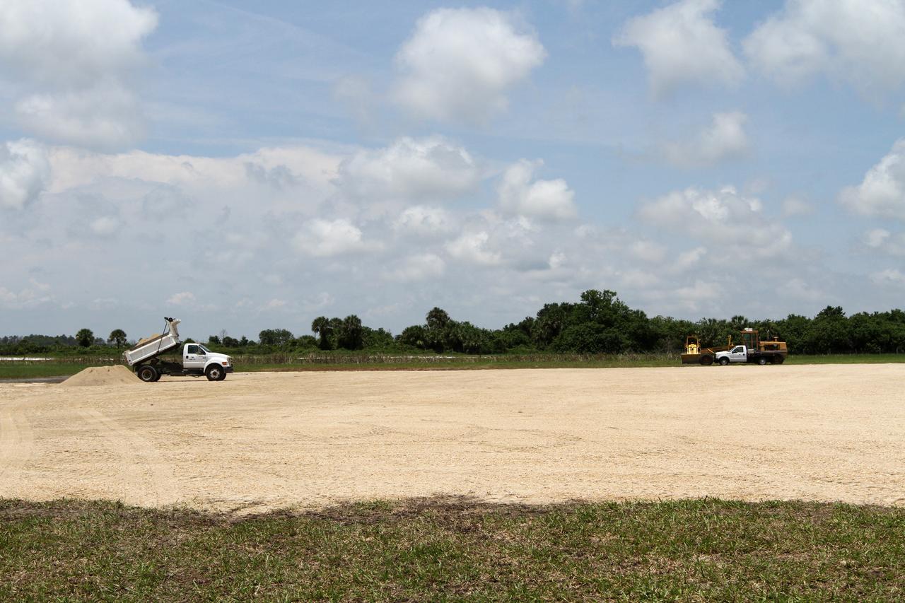 CAPE CANAVERAL, Fla. – Crawlerway fines, rock crushed by the weight of the crawler transporter, is trucked in for the foundation of the hazard field for NASA’s Project Morpheus lander near the Shuttle Landing Facility at NASA’s Kennedy Space Center in Florida. Testing of the prototype lander has been ongoing at NASA's Johnson Space Center in Houston in preparation for its first free flight. The SLF will provide the lander with the kind of field necessary for realistic testing, complete with rocks, craters and hazards to avoid. Morpheus utilizes an autonomous landing and hazard avoidance technology, or ALHAT, payload that will allow it to navigate to clear landing sites amidst rocks, craters and other hazards during its descent. Project Morpheus is one of 20 small projects comprising the Advanced Exploration Systems, or AES, program in NASA's Human Exploration and Operations Mission Directorate. AES projects pioneer new approaches for rapidly developing prototype systems, demonstrating key capabilities and validating operational concepts for future human missions beyond Earth orbit. For more information on Project Morpheus, visit http://www.nasa.gov/centers/johnson/exploration/morpheus/index.html. Photo credit: NASA/Kim Shiflett