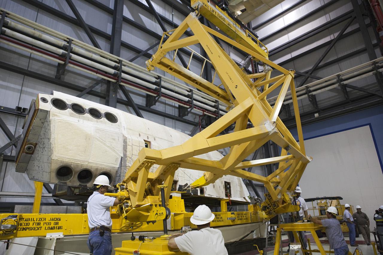 CAPE CANAVERAL, Fla. – Inside Orbiter Processing Facility-1 at NASA’s Kennedy Space Center in Florida, United Launch Alliance technicians provide assistance as a large crane is lowered toward the right orbital maneuvering system, or OMS, pod for space shuttle Atlantis. It will be the last time an OMS pod is installed on Atlantis. The OMS provided the shuttle with thrust for orbit insertion, rendezvous and deorbit, and could provide up to 1,000 pounds of propellant to the aft reaction control system.    The OMS is housed in two independent pods located on each side of the shuttle’s aft fuselage. Each pod contains one OMS engine and the hardware needed to pressurize, store and distribute the propellants to perform the velocity maneuvers. Atlantis’ OMS pods were removed and sent to the test facility at White Sands Space Harbor in New Mexico to be cleaned of residual toxic propellant. The work is part of the Space Shuttle Program’s transition and retirement processing of the space shuttle fleet. A groundbreaking was held Jan. 18 for Atlantis’ future home, a 65,000-square-foot exhibit hall in Shuttle Plaza at the Kennedy Space Center Visitor Complex. Atlantis is scheduled to roll over to the visitor complex in November in preparation for the exhibit’s grand opening in July 2013. For more information, visit http://www.nasa.gov/transition. Photo credit: NASA/Dimitri Gerondidakis