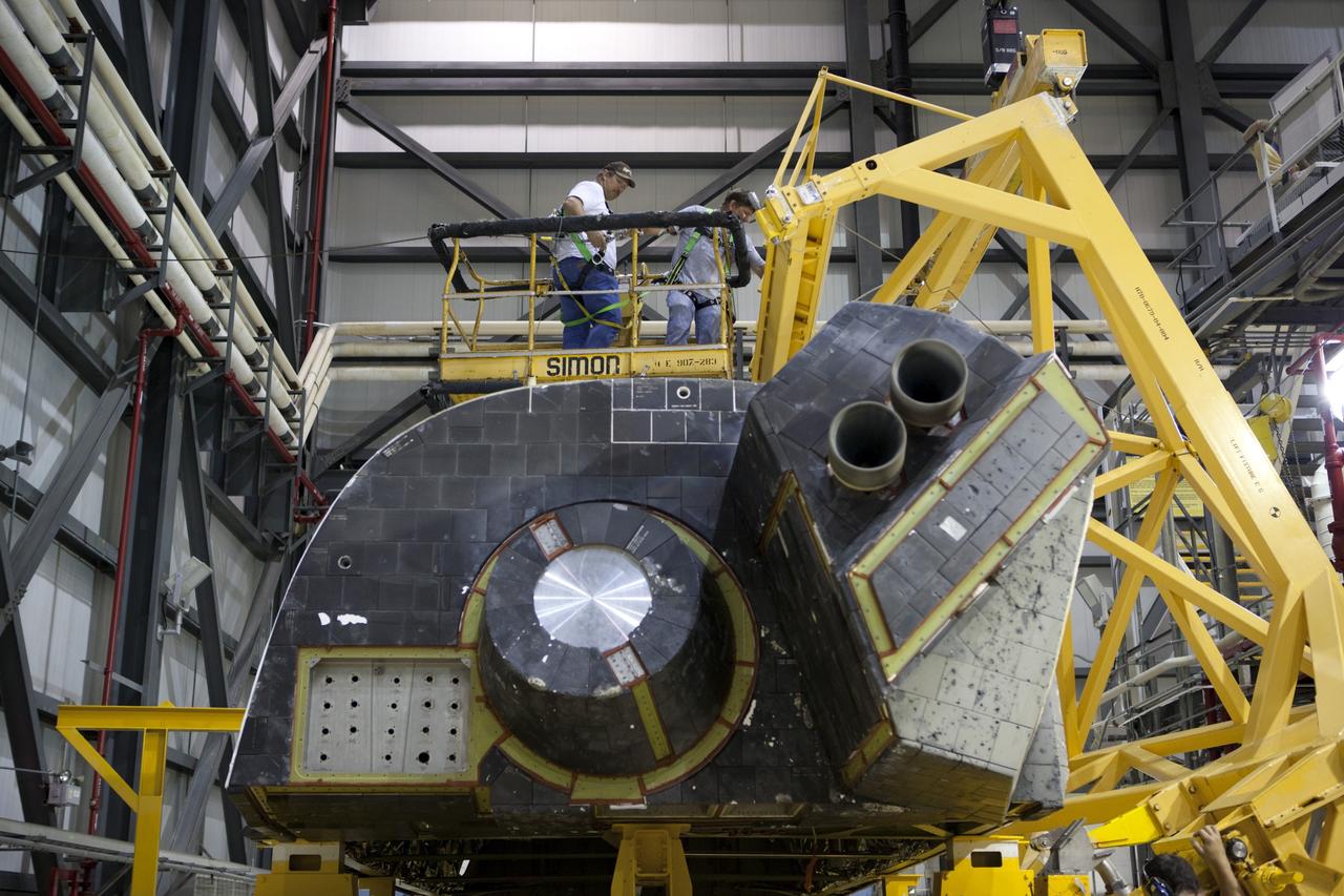 CAPE CANAVERAL, Fla. – Inside Orbiter Processing Facility-1 at NASA’s Kennedy Space Center in Florida, United Launch Alliance technicians monitor the progress as a large crane moves the right orbital maneuvering system, or OMS, pod for installation on space shuttle Atlantis. It will be the last time an OMS pod is installed on Atlantis. The OMS provided the shuttle with thrust for orbit insertion, rendezvous and deorbit, and could provide up to 1,000 pounds of propellant to the aft reaction control system.    The OMS is housed in two independent pods located on each side of the shuttle’s aft fuselage. Each pod contains one OMS engine and the hardware needed to pressurize, store and distribute the propellants to perform the velocity maneuvers. Atlantis’ OMS pods were removed and sent to the test facility at White Sands Space Harbor in New Mexico to be cleaned of residual toxic propellant. The work is part of the Space Shuttle Program’s transition and retirement processing of the space shuttle fleet. A groundbreaking was held Jan. 18 for Atlantis’ future home, a 65,000-square-foot exhibit hall in Shuttle Plaza at the Kennedy Space Center Visitor Complex. Atlantis is scheduled to roll over to the visitor complex in November in preparation for the exhibit’s grand opening in July 2013. For more information, visit http://www.nasa.gov/transition. Photo credit: NASA/Dimitri Gerondidakis