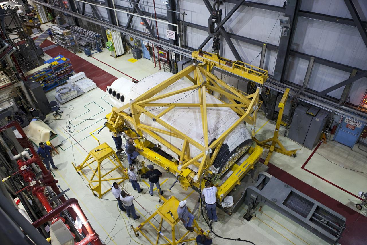 CAPE CANAVERAL, Fla. – In a view from above inside Orbiter Processing Facility-1 at NASA’s Kennedy Space Center in Florida, United Space Alliance technicians monitor the progress as a crane is attached to the right orbital maneuvering system, or OMS, pod for space shuttle Atlantis. It is the last time an OMS pod will be installed on Atlantis. The OMS provided the shuttle with thrust for orbit insertion, rendezvous and deorbit, and could provide up to 1,000 pounds of propellant to the aft reaction control system.    The OMS is housed in two independent pods located on each side of the shuttle’s aft fuselage. Each pod contains one OMS engine and the hardware needed to pressurize, store and distribute the propellants to perform the velocity maneuvers. Atlantis’ OMS pods were removed and sent to the test facility at White Sands Space Harbor in New Mexico to be cleaned of residual toxic propellant. The work is part of the Space Shuttle Program’s transition and retirement processing of the space shuttle fleet. A groundbreaking was held Jan. 18 for Atlantis’ future home, a 65,000-square-foot exhibit hall in Shuttle Plaza at the Kennedy Space Center Visitor Complex. Atlantis is scheduled to roll over to the visitor complex in November in preparation for the exhibit’s grand opening in July 2013. For more information, visit http://www.nasa.gov/transition. Photo credit: NASA/Dimitri Gerondidakis