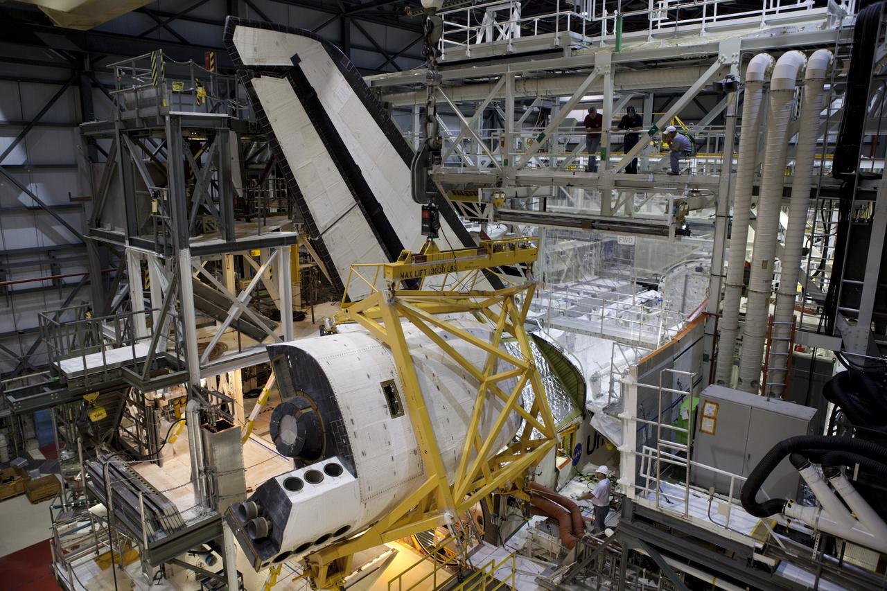 CAPE CANAVERAL, Fla. – Inside Orbiter Processing Facility-1 at NASA’s Kennedy Space Center in Florida, United Space Alliance technicians monitor the progress as a large crane moves the right orbital maneuvering system, or OMS, pod closer to space shuttle Atlantis. It is the last time an OMS pod will be installed on Atlantis. The OMS provided the shuttle with thrust for orbit insertion, rendezvous and deorbit, and could provide up to 1,000 pounds of propellant to the aft reaction control system.    The OMS is housed in two independent pods located on each side of the shuttle’s aft fuselage. Each pod contains one OMS engine and the hardware needed to pressurize, store and distribute the propellants to perform the velocity maneuvers. Atlantis’ OMS pods were removed and sent to the test facility at White Sands Space Harbor in New Mexico to be cleaned of residual toxic propellant. The work is part of the Space Shuttle Program’s transition and retirement processing of the space shuttle fleet. A groundbreaking was held Jan. 18 for Atlantis’ future home, a 65,000-square-foot exhibit hall in Shuttle Plaza at the Kennedy Space Center Visitor Complex. Atlantis is scheduled to roll over to the visitor complex in November in preparation for the exhibit’s grand opening in July 2013. For more information, visit http://www.nasa.gov/transition. Photo credit: NASA/Dimitri Gerondidakis