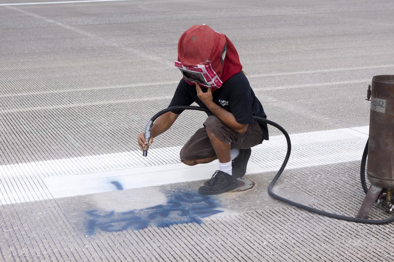 CAPE CANAVERAL, Fla. - At the Shuttle Landing Facility SLF at NASA’s Kennedy Space Center in Florida, United Space Alliance technicians make preparations to mark the final front and rear wheel stop locations of an orbiter. Space shuttle Atlantis completed the STS-135 mission by landing at the SLF on July 21, 2011, at 5:57 a.m.     A special plaque will be permanently mounted at the runway’s edge to commemorate the final shuttle landing. Atlantis flew 33 missions, completed 4,848 orbits of the Earth, traveled nearly 126 million miles and spent 307 days in space. Atlantis carried 207 astronauts to space.  Photo credit: NASA/Jim Grossmann