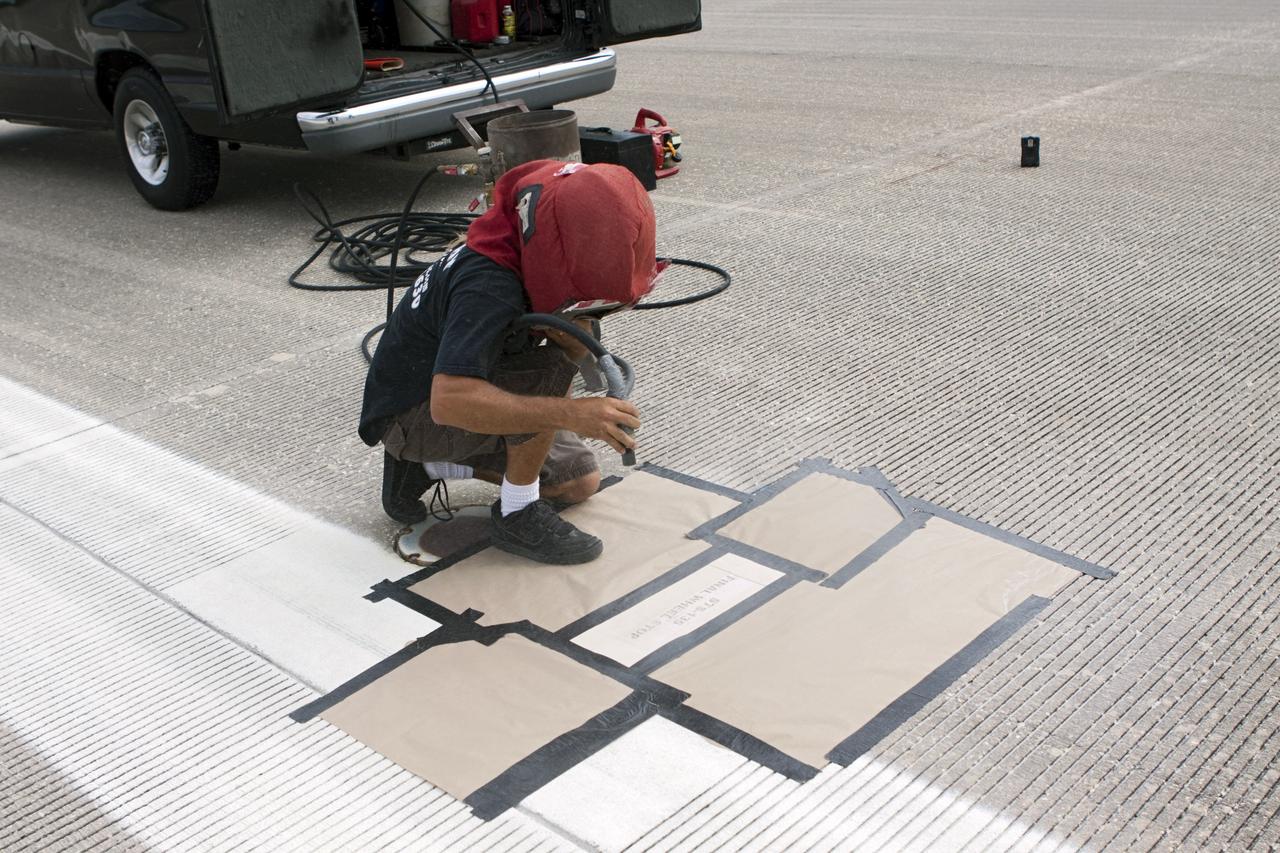 CAPE CANAVERAL, Fla. - At the Shuttle Landing Facility SLF at NASA’s Kennedy Space Center in Florida, a United Space Alliance technician marks the final front and rear wheel stop locations of an orbiter. Space shuttle Atlantis completed the STS-135 mission by landing at the SLF on July 21, 2011, at 5:57 a.m. A special plaque will be permanently mounted at the runway’s edge to commemorate the final shuttle landing. Atlantis flew 33 missions, completed 4,848 orbits of the Earth, traveled nearly 126 million miles and spent 307 days in space. Atlantis carried 207 astronauts to space. Photo credit: NASA/Jim Grossmann