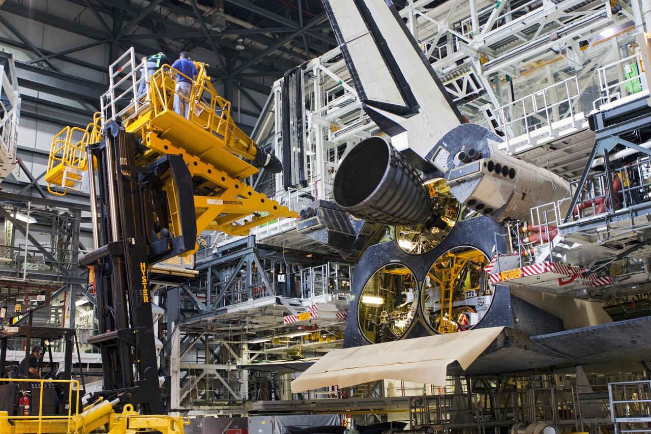 CAPE CANAVERAL, Fla. – In Orbiter Processing Facility-1 at NASA’s Kennedy Space Center in Florida, technicians move the Hyster forklift back after using it to install replica shuttle main engine RSME number 1 on space shuttle Atlantis. Three RSMEs will be installed on Atlantis. The work is part of the Space Shuttle Program’s transition and retirement processing of the space shuttle fleet. A groundbreaking was held Jan. 18 for Atlantis’ future home, a 65,000-square-foot exhibit hall in Shuttle Plaza at the Kennedy Space Center Visitor Complex. Atlantis is scheduled to roll over to the visitor complex in November in preparation for the exhibit’s grand opening in July 2013. For more information, visit http://www.nasa.gov/transition. Photo credit: NASA/Jim Grossmann