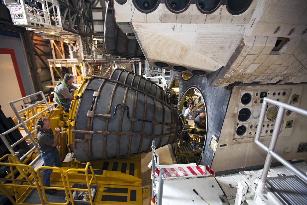 CAPE CANAVERAL, Fla. - In Orbiter Processing Facility Bay 1 at NASA’s Kennedy Space Center in Florida, technicians stand on the Hyster forklift as replica shuttle main engine RSME number 2 is installed on the space shuttle Atlantis. Other technicians work inside the aft compartment securing the RSME in place. Three RSMEs were installed on Atlantis. The replicas were built in the Pratt & Whitney Rocketdyne engine shop at KSC to replace the space shuttle main engines SSMEs which will be placed in storage to support NASA's Space Launch System currently under development. The RSME installation is part of the Space Shuttle Program’s transition and retirement processing of the space shuttle fleet. A groundbreaking was held Jan. 18, 2012 for Atlantis’ future home, a 65,000-square-foot exhibit hall in Shuttle Plaza at the Kennedy Space Center Visitor Complex. Atlantis is scheduled to roll over to the visitor complex during November in preparation for the exhibit’s grand opening in July 2013. For more information, visit http://www.nasa.gov/transition. Photo credit: NASA/Glenn Benson