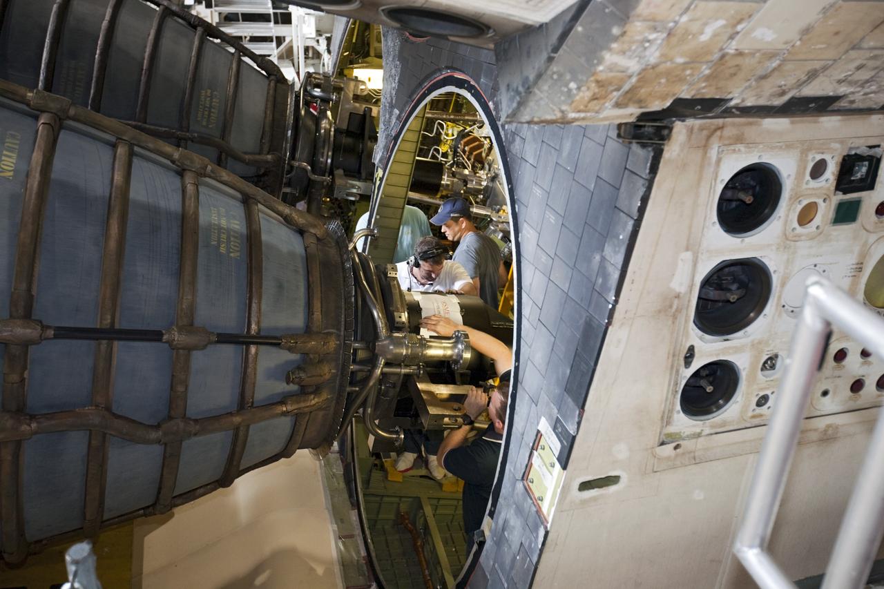 CAPE CANAVERAL, Fla. - In Orbiter Processing Facility Bay 1 at NASA’s Kennedy Space Center in Florida, technicians work inside the aft compartment of Atlantis to secure replica shuttle main engine RSME number 2 in place. Three RSMEs were installed on Atlantis. The replicas were built in the Pratt & Whitney Rocketdyne engine shop at KSC to replace the space shuttle main engines SSMEs which will be placed in storage to support NASA's Space Launch System currently under development. The RSME installation is part of the Space Shuttle Program’s transition and retirement processing of the space shuttle fleet. A groundbreaking was held Jan. 18, 2012 for Atlantis’ future home, a 65,000-square-foot exhibit hall in Shuttle Plaza at the Kennedy Space Center Visitor Complex. Atlantis is scheduled to roll over to the visitor complex during November in preparation for the exhibit’s grand opening in July 2013. For more information, visit http://www.nasa.gov/transition. Photo credit: NASA/Glenn Benson
