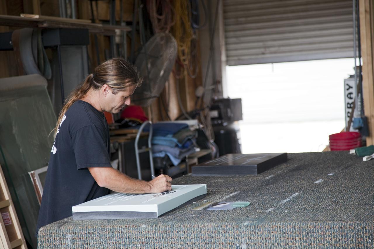 CAPE CANAVERAL, Fla. – At C Spray Glass Blasting of Cocoa Beach, Fla., a worker completes the commemorative plaque to mark space shuttle Atlantis’ wheel stop location. The special plaque will be permanently mounted at the Shuttle Landing Facility, or SLF, runway edge at NASA’s Kennedy Space Center in Florida to commemorate the final space shuttle landing. Atlantis completed the STS-135 mission by landing at the SLF on July 21, 2011, at 5:57 a.m. EDT. Atlantis flew 33 missions, completed 4,848 orbits of the Earth, traveled nearly 126 million miles and spent 307 days in space. Atlantis carried 207 astronauts to space. Photo credit: NASA/Lorne Mathre