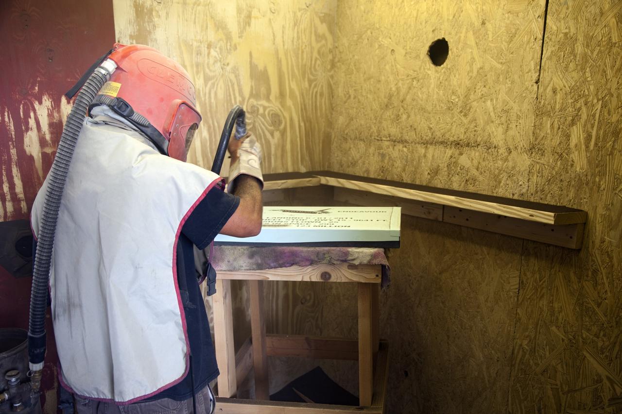 CAPE CANAVERAL, Fla. – At C Spray Glass Blasting of Cocoa Beach, Fla., a worker completes the commemorative plaque to mark space shuttle Atlantis’ wheel stop location. The special plaque will be permanently mounted at the Shuttle Landing Facility, or SLF, runway edge at NASA’s Kennedy Space Center in Florida to commemorate the final space shuttle landing. Atlantis completed the STS-135 mission by landing at the SLF on July 21, 2011, at 5:57 a.m. EDT. Atlantis flew 33 missions, completed 4,848 orbits of the Earth, traveled nearly 126 million miles and spent 307 days in space. Atlantis carried 207 astronauts to space. Photo credit: NASA/Lorne Mathre