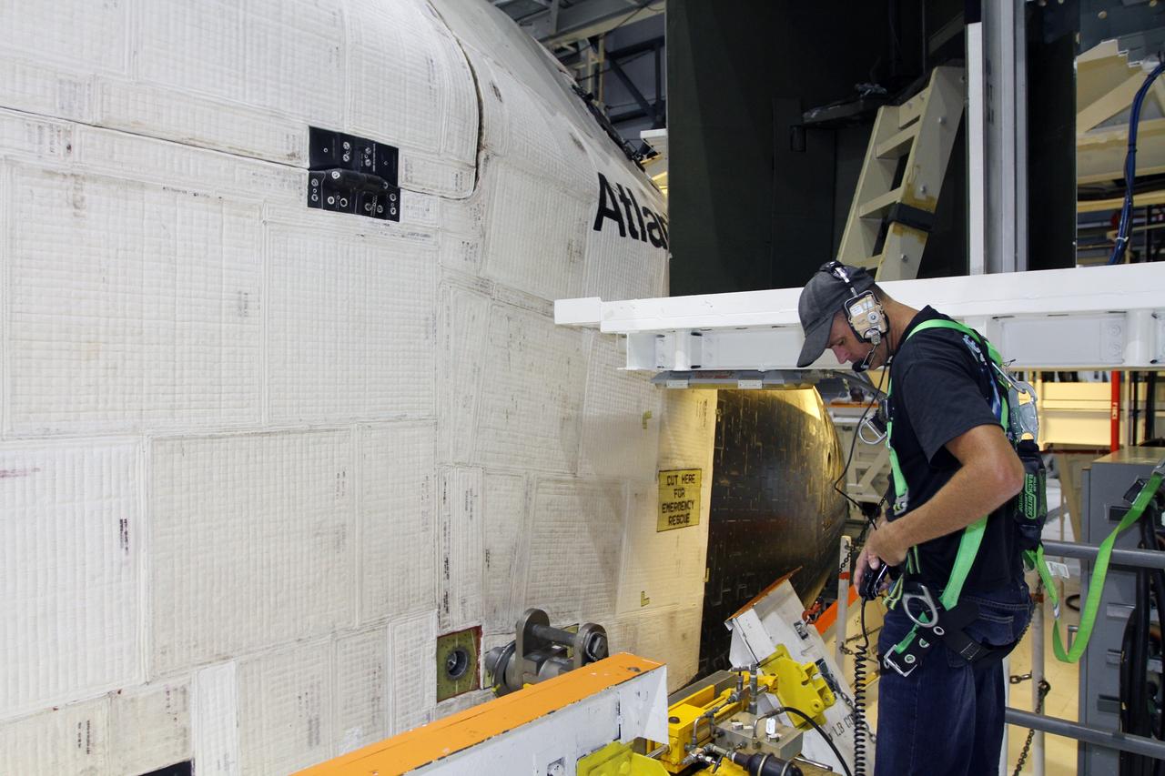 CAPE CANAVERAL, Fla. - While wearing a safety harness, a technician checks his communications equipment during weight and center-of-gravity checks on space shuttle Atlantis in Orbiter Processing Facility Bay 1 at NASA’s Kennedy Space Center in Florida.    The work is part of the Space Shuttle Program’s transition and retirement processing of the shuttle fleet. A groundbreaking was held Jan. 18, 2012, for Atlantis' future home, a 65,000-square-foot exhibit hall in Shuttle Plaza at the Kennedy Space Center Visitor Complex. Atlantis is scheduled to roll over to the visitor complex during November in preparation for the exhibit's grand opening in July 2013. For more information, visit http://www.nasa.gov/transition. Photo credit: NASA/Kim Shiflett