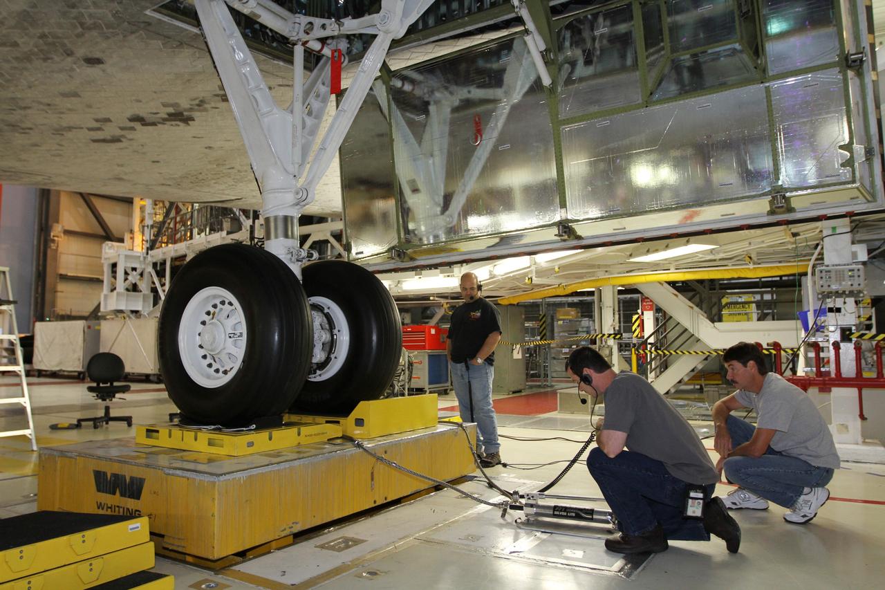 CAPE CANAVERAL, Fla. - Working at the main landing gear, technicians complete weight and center-of-gravity checks of space shuttle Atlantis in Orbiter Processing Facility Bay 1 at NASA’s Kennedy Space Center in Florida.    The work is part of the Space Shuttle Program’s transition and retirement processing of the shuttle fleet. A groundbreaking was held Jan. 18, 2012, for Atlantis' future home, a 65,000-square-foot exhibit hall in Shuttle Plaza at the Kennedy Space Center Visitor Complex. Atlantis is scheduled to roll over to the visitor complex during November in preparation for the exhibit's grand opening in July 2013. For more information, visit http://www.nasa.gov/transition. Photo credit: NASA/Kim Shiflett