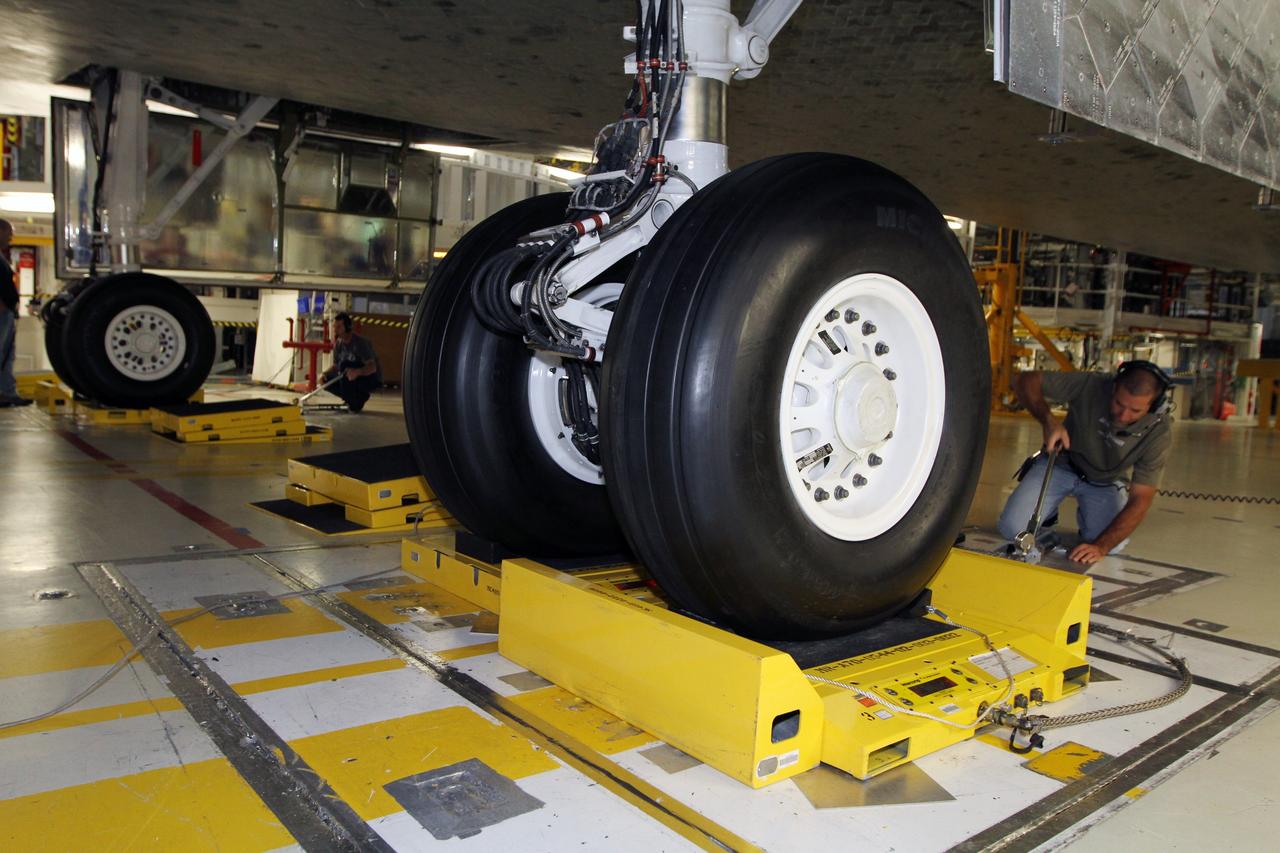 CAPE CANAVERAL, Fla. - Working at the main landing gear, a technician supports weight and center-of-gravity checks of space shuttle Atlantis in Orbiter Processing Facility Bay 1 at NASA’s Kennedy Space Center in Florida.    The work is part of the Space Shuttle Program’s transition and retirement processing of the shuttle fleet. A groundbreaking was held Jan. 18, 2012, for Atlantis' future home, a 65,000-square-foot exhibit hall in Shuttle Plaza at the Kennedy Space Center Visitor Complex. Atlantis is scheduled to roll over to the visitor complex during November in preparation for the exhibit's grand opening in July 2013. For more information, visit http://www.nasa.gov/transition. Photo credit: NASA/Kim Shiflett