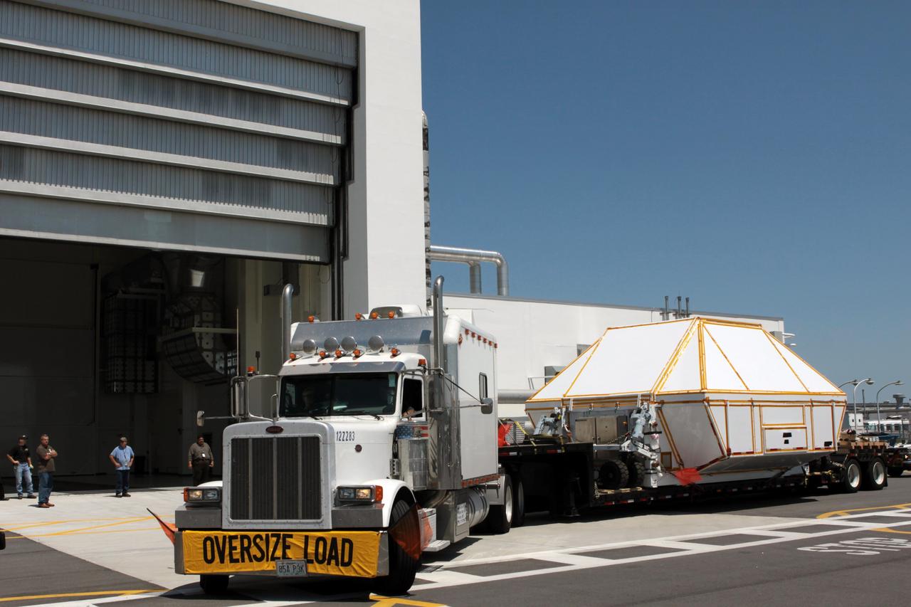 CAPE CANAVERAL, Fla. - Secured inside a transportation container, the Orion crew module arrives at the Operations and Checkout Building at NASA's Kennedy Space Center in Florida.     Slated for Exploration Flight Test-1, an uncrewed mission planned for 2014, the capsule will travel farther into space than any human spacecraft has gone in more than 40 years. NASA's Michoud Assembly Facility in New Orleans built the crew module pressure vessel. The Orion production team will prepare the module for flight by installing heat-shielding thermal protection systems, avionics and other subsystems. For more information, visit http://www.nasa.gov/orion. Photo credit: NASA/Jim Grossmann