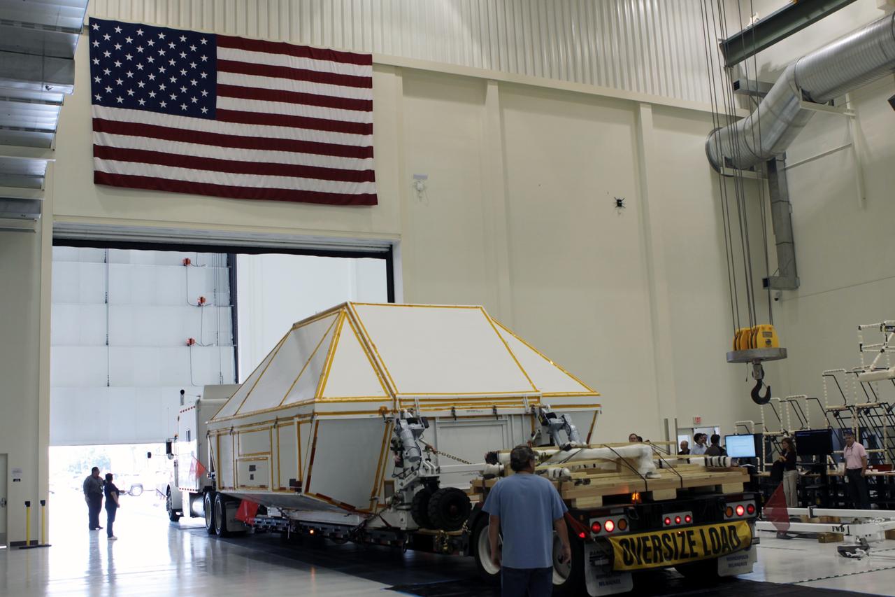 CAPE CANAVERAL, Fla. - The Orion crew module, packed inside a transportation canister, arrives inside the high bay of the Operations and Checkout Building at NASA's Kennedy Space Center in Florida.      Slated for Exploration Flight Test-1, an uncrewed mission planned for 2014, the capsule will travel farther into space than any human spacecraft has gone in more than 40 years. NASA's Michoud Assembly Facility in New Orleans built the crew module pressure vessel. The Orion production team will prepare the module for flight by installing heat-shielding thermal protection systems, avionics and other subsystems. For more information, visit http://www.nasa.gov/orion. Photo credit: NASA/Jim Grossmann