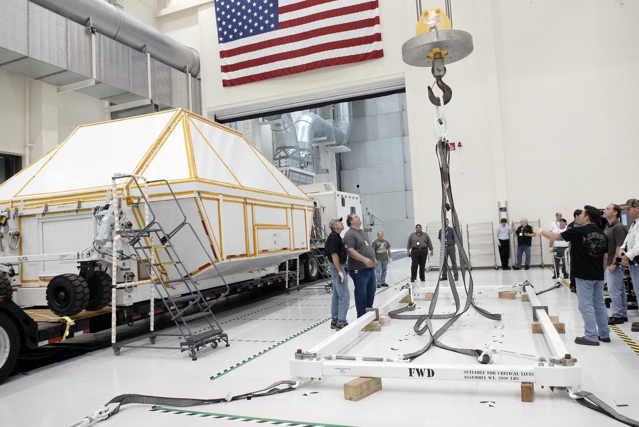 CAPE CANAVERAL, Fla. - At NASA's Kennedy Space Center in Florida, workers inside the Operations and Checkout Building high bay prepare to lift the Orion crew module, secured inside the transportation container at left.      Slated for Exploration Flight Test-1, an uncrewed mission planned for 2014, the capsule will travel farther into space than any human spacecraft has gone in more than 40 years. NASA's Michoud Assembly Facility in New Orleans built the crew module pressure vessel. The Orion production team will prepare the module for flight by installing heat-shielding thermal protection systems, avionics and other subsystems. For more information, visit http://www.nasa.gov/orion. Photo credit: NASA/Charisse Nahser