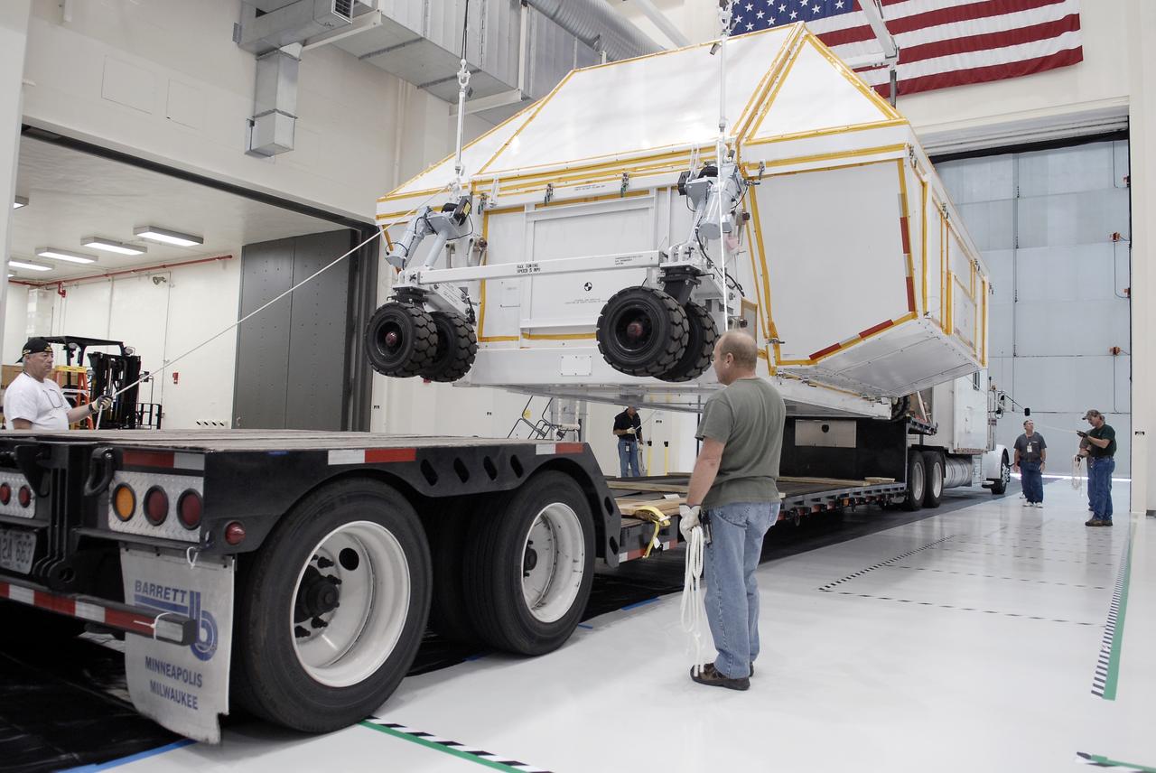 CAPE CANAVERAL, Fla. - The transportation canister holding the Orion crew module is lifted off the back of the truck that delivered it to the Operations and Checkout Building high bay at NASA's Kennedy Space Center in Florida.      Slated for Exploration Flight Test-1, an uncrewed mission planned for 2014, the capsule will travel farther into space than any human spacecraft has gone in more than 40 years. NASA's Michoud Assembly Facility in New Orleans built the crew module pressure vessel. The Orion production team will prepare the module for flight by installing heat-shielding thermal protection systems, avionics and other subsystems. For more information, visit http://www.nasa.gov/orion. Photo credit: NASA/Charisse Nahser