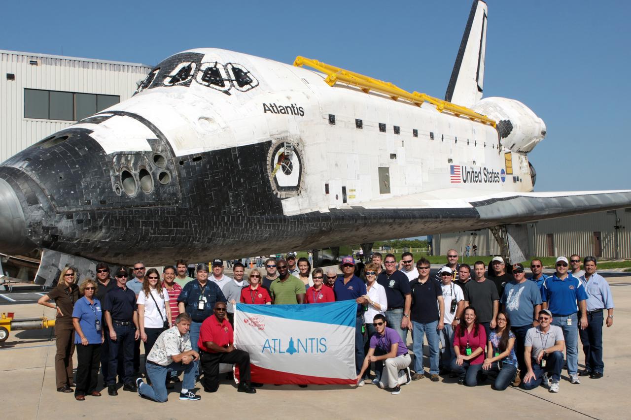 CAPE CANAVERAL, Fla. - Space shuttle team members proudly display an Atlantis flag as the spacecraft paused during its move from Orbiter Processing Facility Bay 1 into High Bay 4 of the nearby Vehicle Assembly Building at NASA's Kennedy Space Center in Florida.    The work is part of the Space Shuttle Program's transition and retirement processing of the space shuttle fleet. A groundbreaking was held Jan. 18 for Atlantis' future home, a 65,000-square-foot exhibit hall in Shuttle Plaza at the Kennedy Space Center Visitor Complex. Atlantis is scheduled to roll over to the visitor complex in November in preparation for the exhibit's grand opening in July 2013. For more information, visit http://www.nasa.gov/transition. Photo credit: NASA/Jim Grossmann