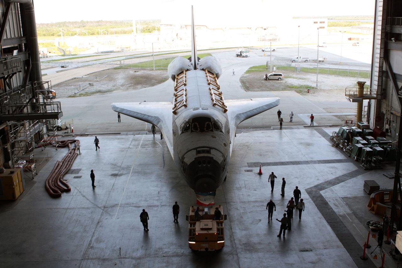CAPE CANAVERAL, Fla. - Technicians accompany space shuttle Atlantis as it is towed into High Bay 4 of the Vehicle Assembly Building after a short move from Orbiter Processing Facility Bay 1 at NASA's Kennedy Space Center.    The work is part of the Space Shuttle Program's transition and retirement processing of the space shuttle fleet. A groundbreaking was held Jan. 18 for Atlantis' future home, a 65,000-square-foot exhibit hall in Shuttle Plaza at the Kennedy Space Center Visitor Complex. Atlantis is scheduled to roll over to the visitor complex in November in preparation for the exhibit's grand opening in July 2013. For more information, visit http://www.nasa.gov/transition. Photo credit: NASA/Jim Grossmann