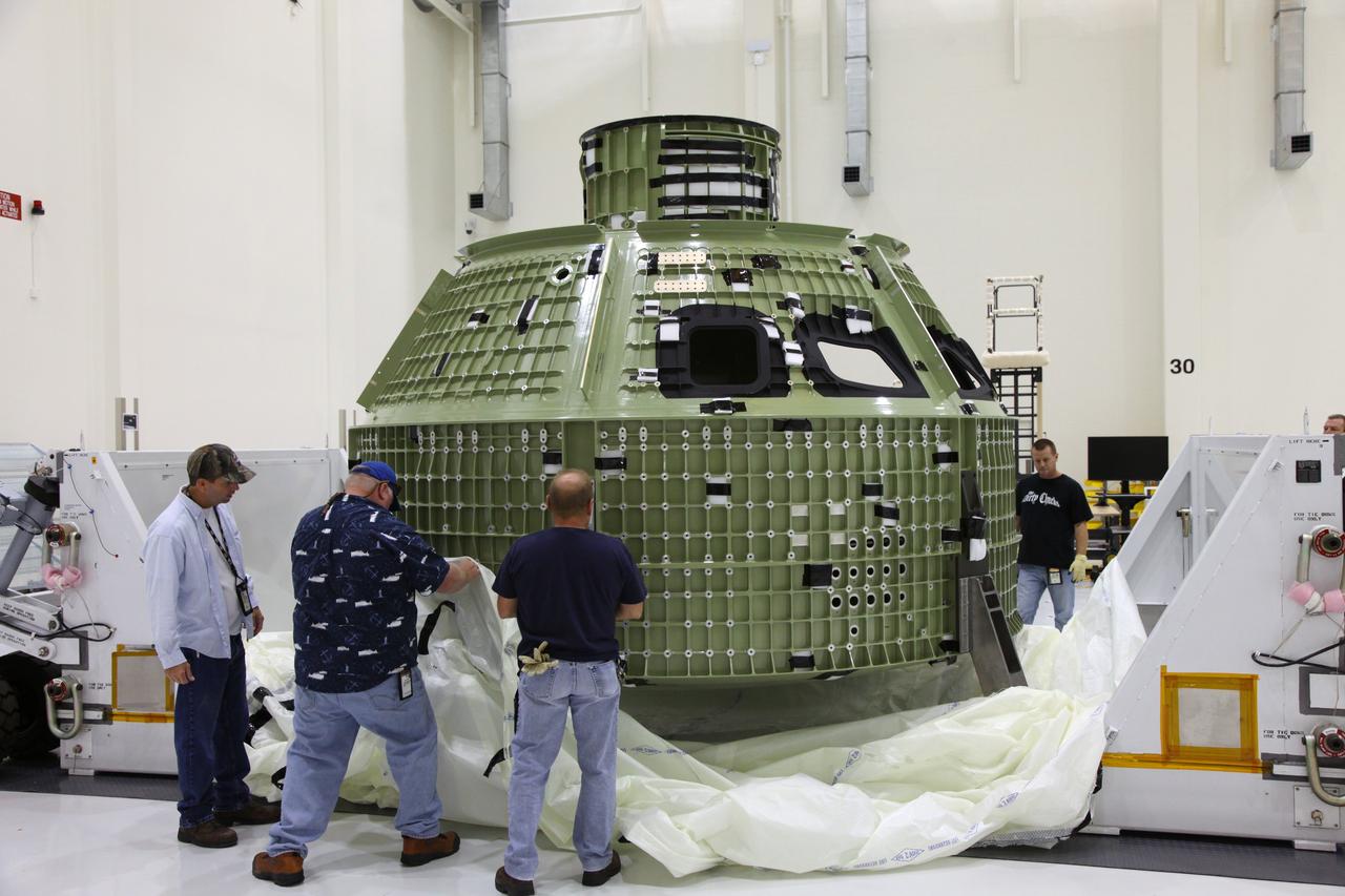 CAPE CANAVERAL, Fla. - The Orion crew module is unwrapped after its arrival in the Operations and Checkout Building high bay at NASA's Kennedy Space Center in Florida.     Slated for Exploration Flight Test-1, an uncrewed mission planned for 2014, the capsule will travel farther into space than any human spacecraft has gone in more than 40 years. NASA's Michoud Assembly Facility in New Orleans built the crew module pressure vessel. The Orion production team will prepare the module for flight by installing heat-shielding thermal protection systems, avionics and other subsystems. For more information, visit http://www.nasa.gov/orion. Photo credit: NASA/Gianni Woods