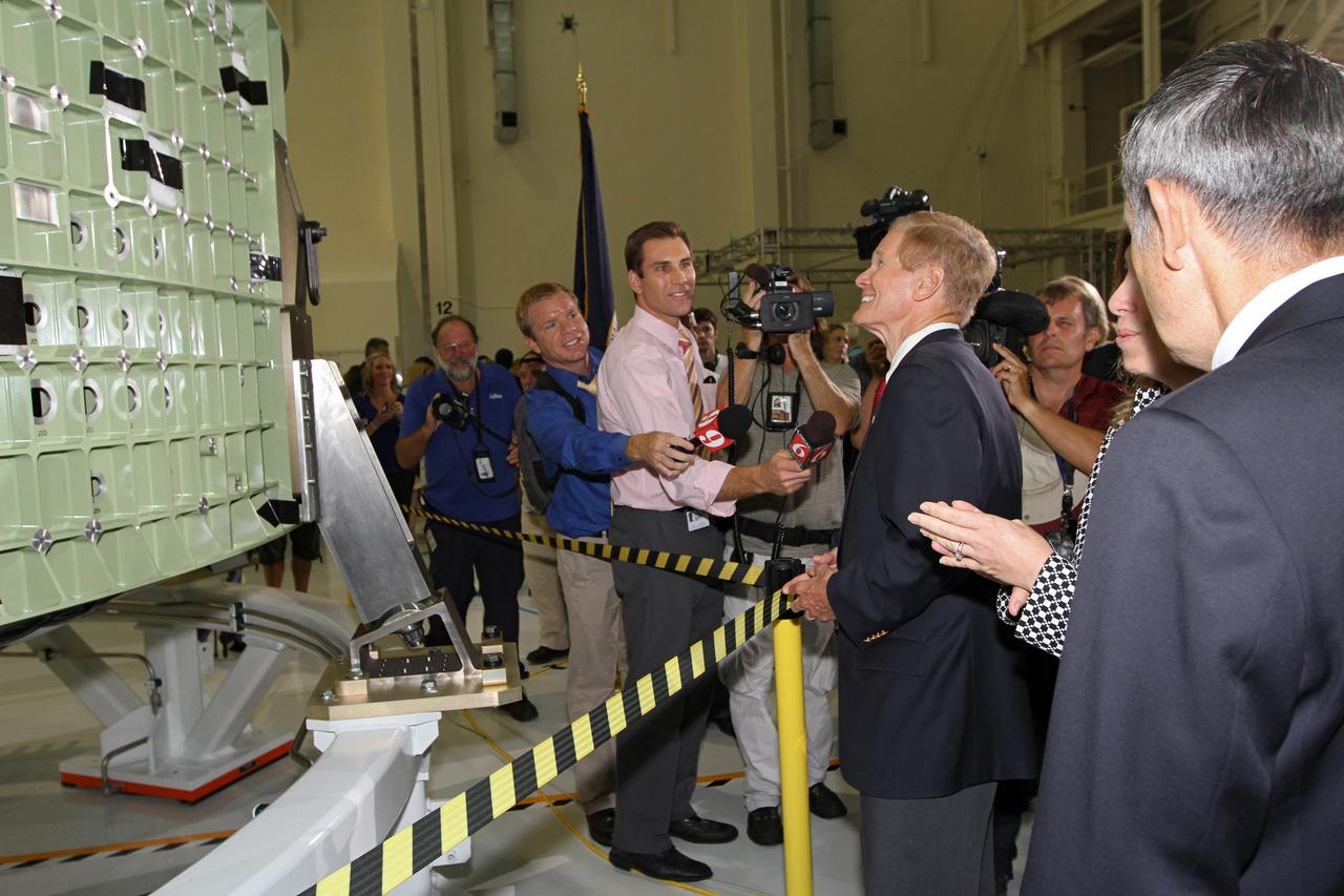 CAPE CANAVERAL, Fla. – U.S. Senator Bill Nelson, center, takes questions from the media in Kennedy Space Center's Operations and Checkout Building high bay following an event marking the arrival in Florida of NASA's first space-bound Orion capsule.  NASA Deputy Director Lori Garver and Kennedy Space Center Director Robert Cabana talk nearby.    Slated for Exploration Flight Test-1, an uncrewed mission planned for 2014, the capsule will travel farther into space than any human spacecraft has gone in more than 40 years. The capsule was shipped to Kennedy from NASA's Michoud Assembly Facility in New Orleans where the crew module pressure vessel was built. The Orion production team will prepare the module for flight at Kennedy by installing heat-shielding thermal protection systems, avionics and other subsystems. For more information, visit http://www.nasa.gov/orion.  Photo credit: NASA/Kim Shiflett