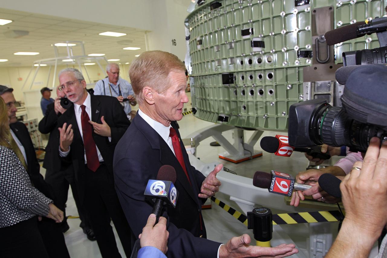 CAPE CANAVERAL, Fla. – U.S. Senator Bill Nelson, center, takes questions from the media in Kennedy Space Center's Operations and Checkout Building high bay following an event marking the arrival in Florida of NASA's first space-bound Orion capsule. Behind Nelson, NASA's Orion Program Manager Mark Geyer talks to NASA Deputy Director Lori Garver and Kennedy Space Center Director Robert Cabana.    Slated for Exploration Flight Test-1, an uncrewed mission planned for 2014, the capsule will travel farther into space than any human spacecraft has gone in more than 40 years. The capsule was shipped to Kennedy from NASA's Michoud Assembly Facility in New Orleans where the crew module pressure vessel was built. The Orion production team will prepare the module for flight at Kennedy by installing heat-shielding thermal protection systems, avionics and other subsystems. For more information, visit http://www.nasa.gov/orion.  Photo credit: NASA/Kim Shiflett