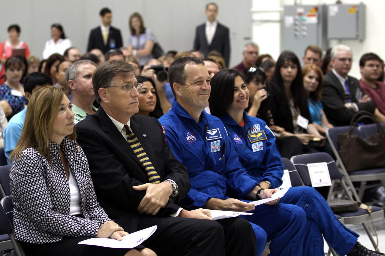 CAPE CANAVERAL, Fla. – NASA dignitaries await their turns at the podium in Kennedy Space Center's Operations and Checkout Building high bay during an event marking the arrival of NASA's first space-bound Orion capsule in Florida.  From left are NASA Deputy Administrator Lori Garver Dan Dumbacher, NASA deputy associate administrator for Exploration Systems Development and NASA astronauts Ricky Arnold and Nicole Stott.     Slated for Exploration Flight Test-1, an uncrewed mission planned for 2014, the capsule will travel farther into space than any human spacecraft has gone in more than 40 years. The capsule was shipped to Kennedy from NASA's Michoud Assembly Facility in New Orleans where the crew module pressure vessel was built. The Orion production team will prepare the module for flight at Kennedy by installing heat-shielding thermal protection systems, avionics and other subsystems. For more information, visit http://www.nasa.gov/orion.  Photo credit: NASA/Kim Shiflett