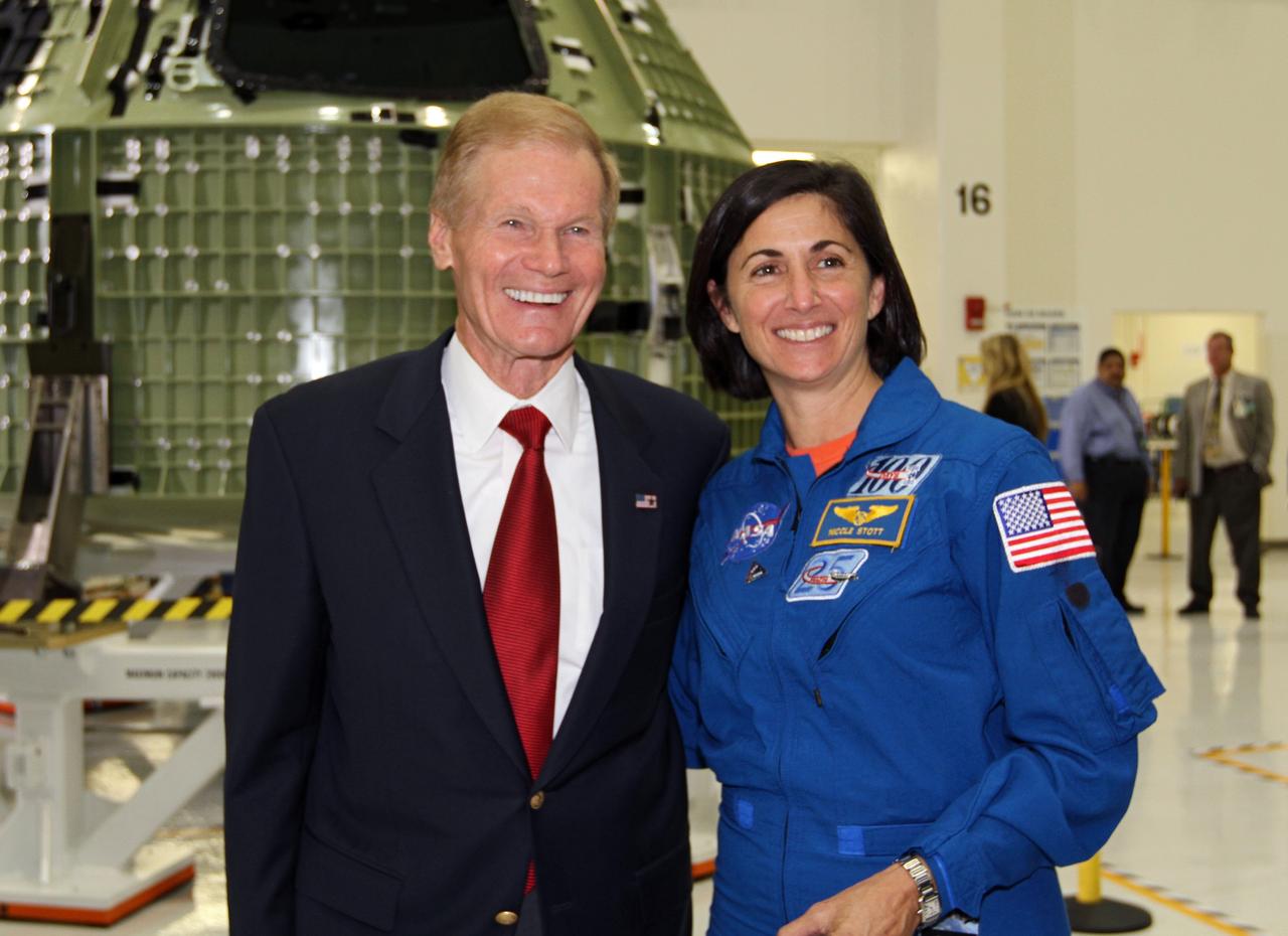 CAPE CANAVERAL, Fla. – From left, U.S. Senator Bill Nelson and NASA astronaut Nicole Stott pose for a portrait in front of NASA's first space-bound Orion capsule in Kennedy's Operations and Checkout Building high bay following an event marking the spacecraft's arrival in Florida.    Slated for Exploration Flight Test-1, an uncrewed mission planned for 2014, the capsule will travel farther into space than any human spacecraft has gone in more than 40 years. The capsule was shipped to Kennedy from NASA's Michoud Assembly Facility in New Orleans where the crew module pressure vessel was built. The Orion production team will prepare the module for flight at Kennedy by installing heat-shielding thermal protection systems, avionics and other subsystems. For more information, visit http://www.nasa.gov/orion.  Photo credit: NASA/Kim Shiflett