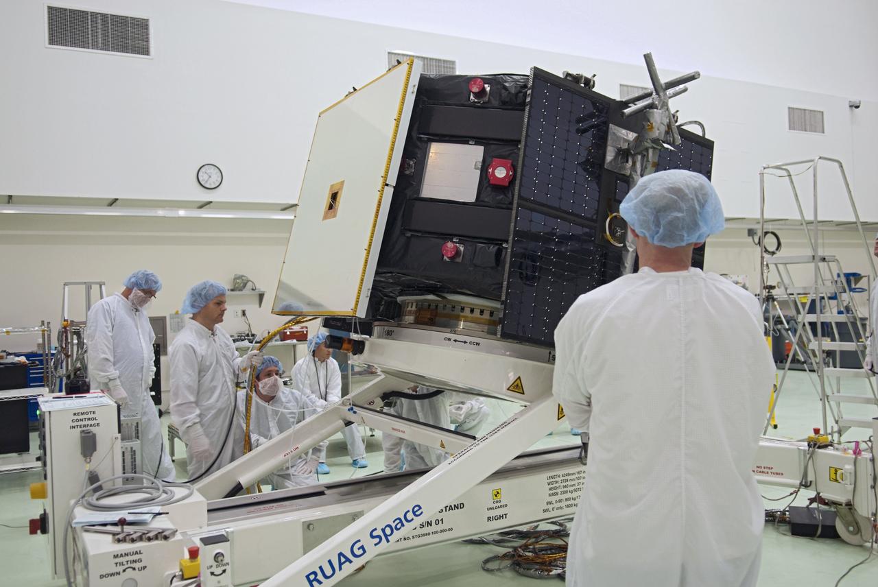 CAPE CANAVERAL, Fla. - Inside the Astrotech payload processing facility near NASA’s Kennedy Space Center in Florida, technicians rotate the Radiation Belt Storm Probes, or RBSP, spacecraft A so they can deploy the spacecraft's remaining three solar panels. Deploying these arrays is standard procedure to ensure they work properly on Earth before they head into space. NASA’s RBSP mission will help us understand the sun’s influence on Earth and near-Earth space by studying the Earth’s radiation belts on various scales of space and time. As the spacecraft orbits Earth, four panels will continuously face the sun to provide constant power to its instruments. RBSP will begin its mission of exploration of Earth’s Van Allen radiation belts and the extremes of space weather after its launch aboard a United Launch Alliance Atlas V rocket. Launch is targeted for Aug. 23. For more information, visit http://www.nasa.gov/rbsp. Photo credit: NASA/Charisse Nahser