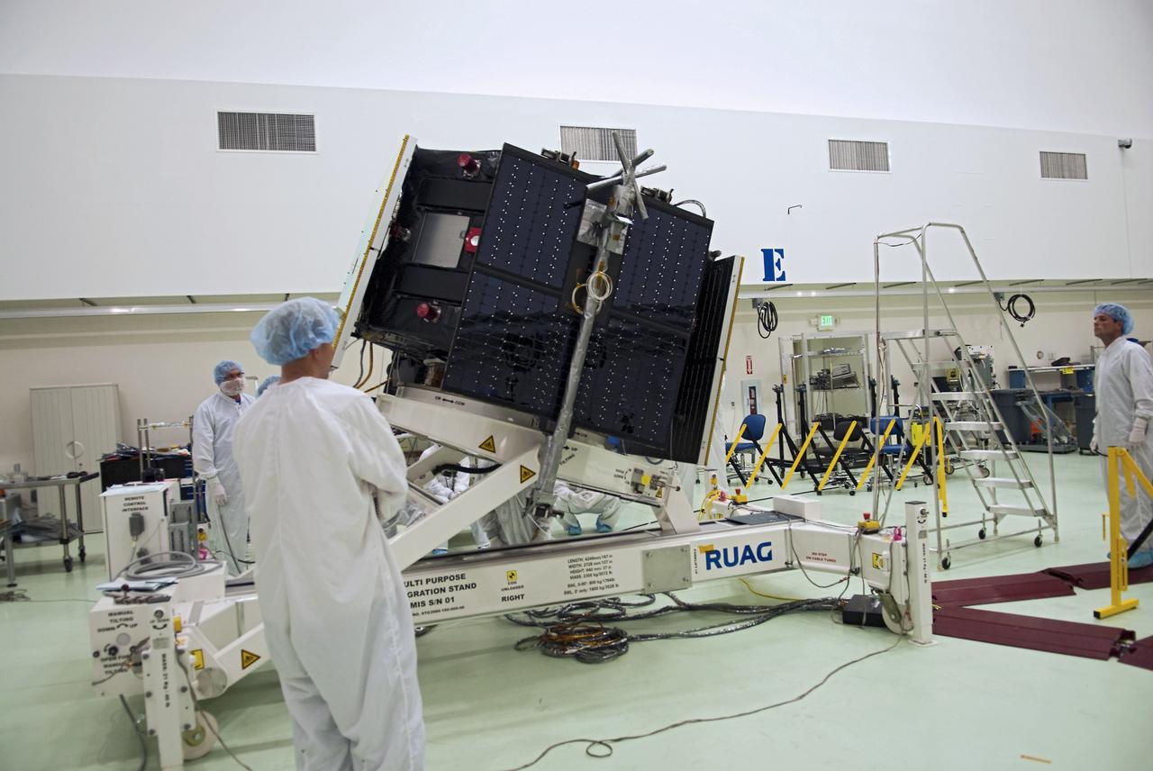 CAPE CANAVERAL, Fla. - Inside the Astrotech payload processing facility near NASA’s Kennedy Space Center in Florida, technicians rotate the Radiation Belt Storm Probes, or RBSP, spacecraft A so they can deploy the spacecraft's remaining three solar panels. Deploying these arrays is standard procedure to ensure they work properly on Earth before they head into space. NASA’s RBSP mission will help us understand the sun’s influence on Earth and near-Earth space by studying the Earth’s radiation belts on various scales of space and time. As the spacecraft orbits Earth, four panels will continuously face the sun to provide constant power to its instruments. RBSP will begin its mission of exploration of Earth’s Van Allen radiation belts and the extremes of space weather after its launch aboard a United Launch Alliance Atlas V rocket. Launch is targeted for Aug. 23. For more information, visit http://www.nasa.gov/rbsp. Photo credit: NASA/Charisse Nahser