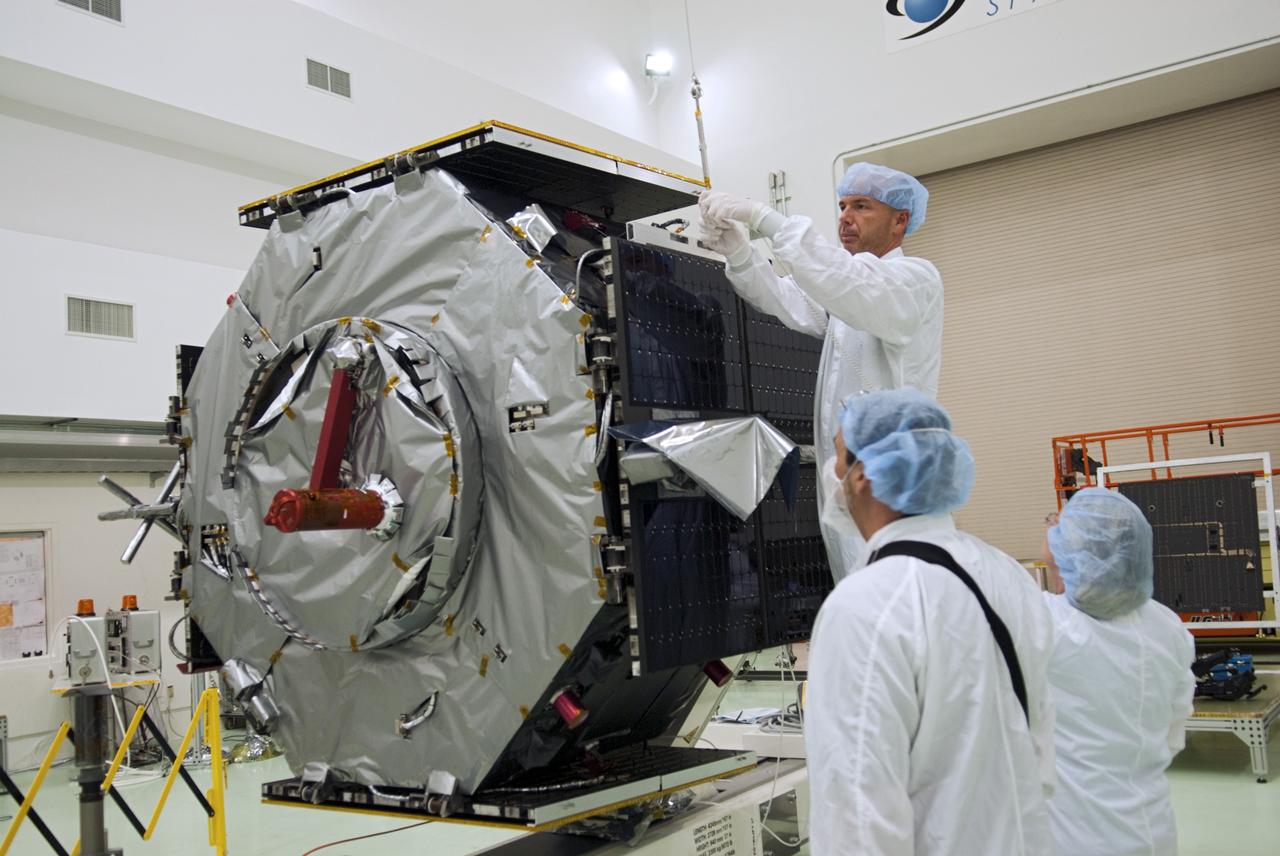 CAPE CANAVERAL, Fla. - Inside the Astrotech payload processing facility near NASA’s Kennedy Space Center in Florida, technicians prepare to deploy the solar arrays and magnetometer boom of the Radiation Belt Storm Probes, or RBSP, spacecraft A. Deploying these components are standard procedure to ensure they work properly on Earth before they head into space.    NASA’s RBSP mission will help us understand the sun’s influence on Earth and near-Earth space by studying the Earth’s radiation belts on various scales of space and time. As the spacecraft orbits Earth, the four solar panels will continuously face the sun to provide constant power to its instruments. The boom will provide data of the electric fields that energize radiation particles and modify the structure of the inner magnetosphere. RBSP will begin its mission of exploration of Earth’s Van Allen radiation belts and the extremes of space weather after its launch aboard a United Launch Alliance Atlas V rocket. Launch is targeted for Aug. 23. For more information, visit http://www.nasa.gov/rbsp. Photo credit: NASA/Charisse Nahser
