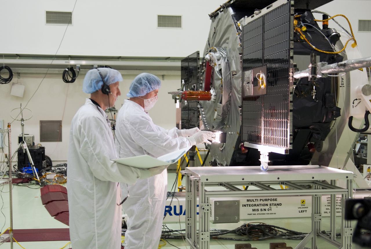 CAPE CANAVERAL, Fla. - Inside the Astrotech payload processing facility near NASA’s Kennedy Space Center in Florida, technicians perform a solar array illumination test after the solar arrays and magnetometer boom were deployed on the Radiation Belt Storm Probes, or RBSP, spacecraft A. Deploying these components are a standard procedure to ensure they work properly on Earth before they head into space. NASA’s RBSP mission will help us understand the sun’s influence on Earth and near-Earth space by studying the Earth’s radiation belts on various scales of space and time. As the spacecraft orbits Earth, the four solar panels will continuously face the sun to provide constant power to its instruments. The boom will provide data of the electric fields that energize radiation particles and modify the structure of the inner magnetosphere. RBSP will begin its mission of exploration of Earth’s Van Allen radiation belts and the extremes of space weather after its launch aboard a United Launch Alliance Atlas V rocket. Launch is targeted for Aug. 23. For more information, visit http://www.nasa.gov/rbsp. Photo credit: NASA/Charisse Nahser