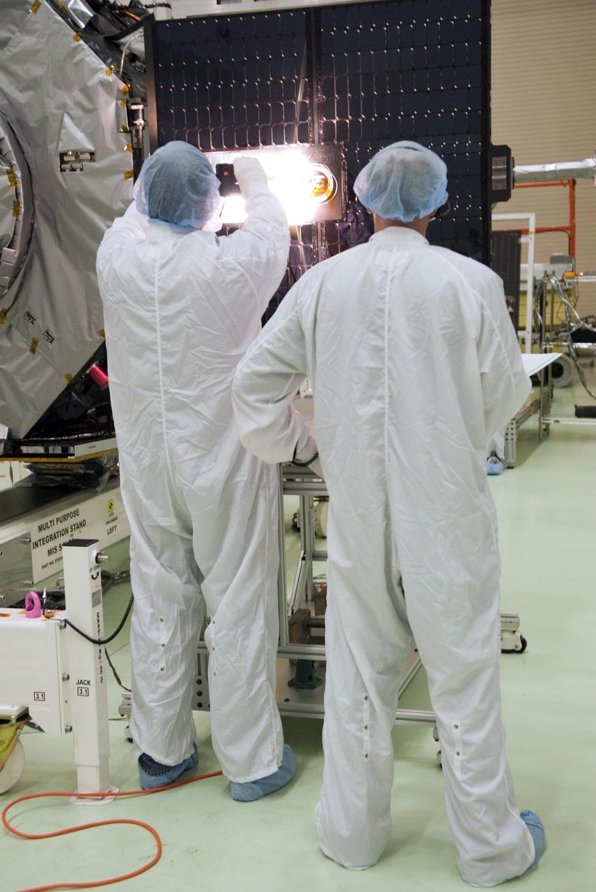 CAPE CANAVERAL, Fla. - Inside the Astrotech payload processing facility near NASA’s Kennedy Space Center in Florida, technicians perform a solar array illumination test after the solar arrays and magnetometer boom were deployed on the Radiation Belt Storm Probes, or RBSP, spacecraft A. Deploying these components are a standard procedure to ensure they work properly on Earth before they head into space. NASA’s RBSP mission will help us understand the sun’s influence on Earth and near-Earth space by studying the Earth’s radiation belts on various scales of space and time. As the spacecraft orbits Earth, the four solar panels will continuously face the sun to provide constant power to its instruments. The boom will provide data of the electric fields that energize radiation particles and modify the structure of the inner magnetosphere. RBSP will begin its mission of exploration of Earth’s Van Allen radiation belts and the extremes of space weather after its launch aboard a United Launch Alliance Atlas V rocket. Launch is targeted for Aug. 23. For more information, visit http://www.nasa.gov/rbsp. Photo credit: NASA/Charisse Nahser
