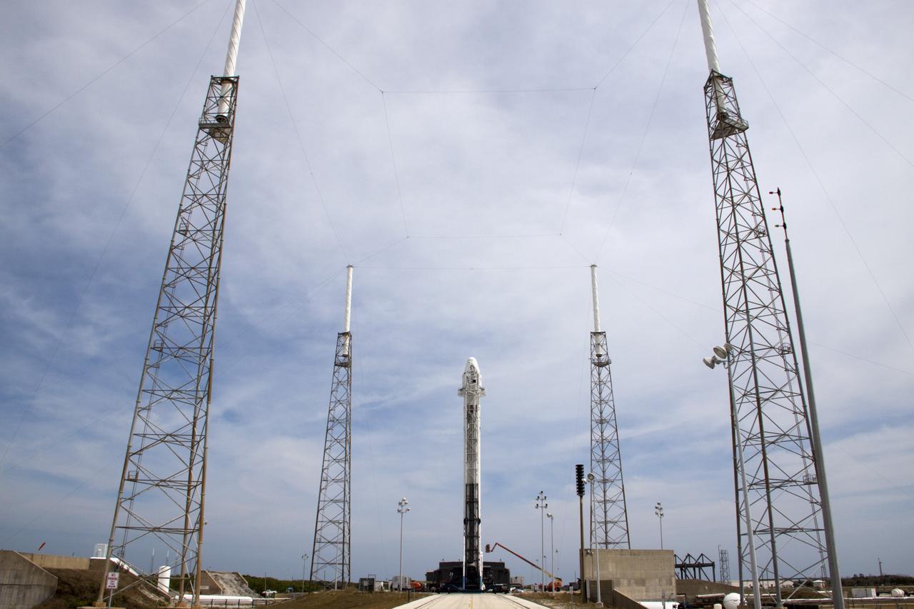CAPE CANAVERAL, Fla. – Surrounded by four lightning suppression system towers, the SpaceX Falcon 9 rocket stands at Space Launch Complex-40 on Cape Canaveral Air Force Station in Florida. Liftoff with the SpaceX Dragon capsule aboard is set for 4:55 a.m. EDT on May 19. The launch will be the company's second demonstration test flight for NASA's Commercial Orbital Transportation Services Program, or COTS.    During the flight, the capsule will conduct a series of check-out procedures to test and prove its systems, including rendezvous and berthing with the International Space Station. If the capsule performs as planned, the cargo and experiments it is carrying will be transferred to the station. The cargo includes food, water and provisions for the station’s Expedition crews, such as clothing, batteries and computer equipment. Under COTS, NASA has partnered with two aerospace companies to deliver cargo to the station. For more information, visit http://www.nasa.gov/spacex Photo credit: NASA/Jim Grossmann