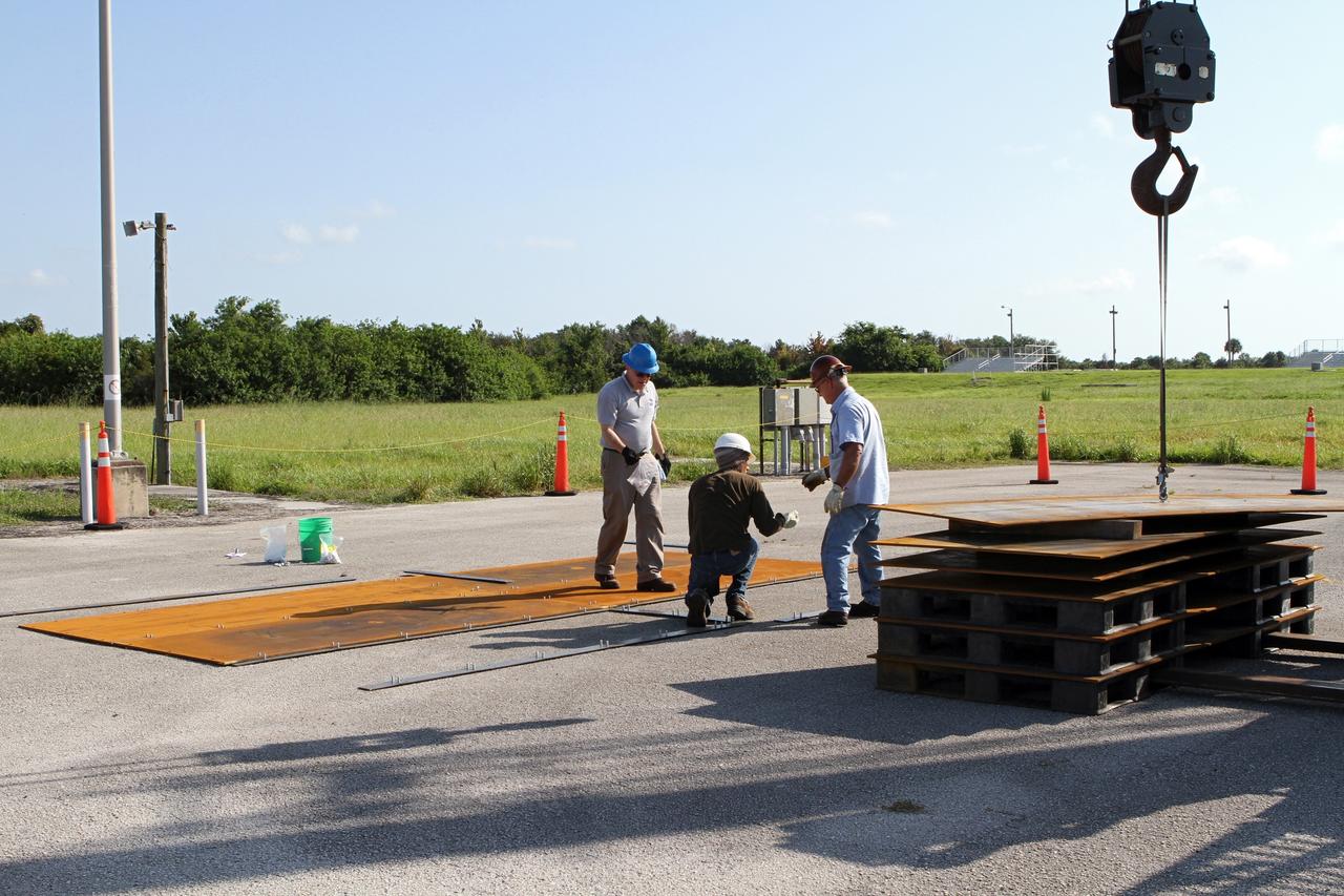 CAPE CANAVERAL, Fla. – Workers begin construction of the launch platform for the Project Morpheus lander at the midfield of the Shuttle Landing Facility, or SLF, at NASA’s Kennedy Space Center in Florida. Testing of the prototype lander has been ongoing at NASA’s Johnson Space Center in Houston in preparation for its first free flight. The SLF will provide the lander with the kind of field necessary for realistic testing, complete with rocks, craters and hazards to avoid. Morpheus utilizes an autonomous landing and hazard avoidance technology, or ALHAT, payload that will allow it to navigate to clear landing sites amidst rocks, craters and other hazards during its descent. Project Morpheus is one of 20 small projects comprising the Advanced Exploration Systems, or AES, program in NASA’s Human Exploration and Operations Mission Directorate. AES projects pioneer new approaches for rapidly developing prototype systems, demonstrating key capabilities and validating operational concepts for future human missions beyond Earth orbit. For more information on Project Morpheus, visit http://www.nasa.gov/centers/johnson/exploration/morpheus/index.html. Photo credit: NASA/Kim Shiflett