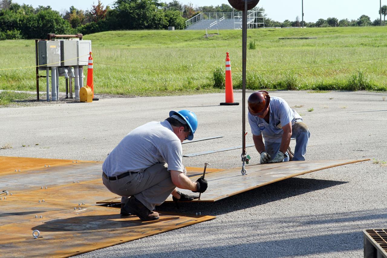 CAPE CANAVERAL, Fla. – Workers begin construction of the launch platform for the Project Morpheus lander at the midfield of the Shuttle Landing Facility, or SLF, at NASA’s Kennedy Space Center in Florida. Testing of the prototype lander has been ongoing at NASA’s Johnson Space Center in Houston in preparation for its first free flight. The SLF will provide the lander with the kind of field necessary for realistic testing, complete with rocks, craters and hazards to avoid. Morpheus utilizes an autonomous landing and hazard avoidance technology, or ALHAT, payload that will allow it to navigate to clear landing sites amidst rocks, craters and other hazards during its descent. Project Morpheus is one of 20 small projects comprising the Advanced Exploration Systems, or AES, program in NASA’s Human Exploration and Operations Mission Directorate. AES projects pioneer new approaches for rapidly developing prototype systems, demonstrating key capabilities and validating operational concepts for future human missions beyond Earth orbit. For more information on Project Morpheus, visit http://www.nasa.gov/centers/johnson/exploration/morpheus/index.html. Photo credit: NASA/Kim Shiflett