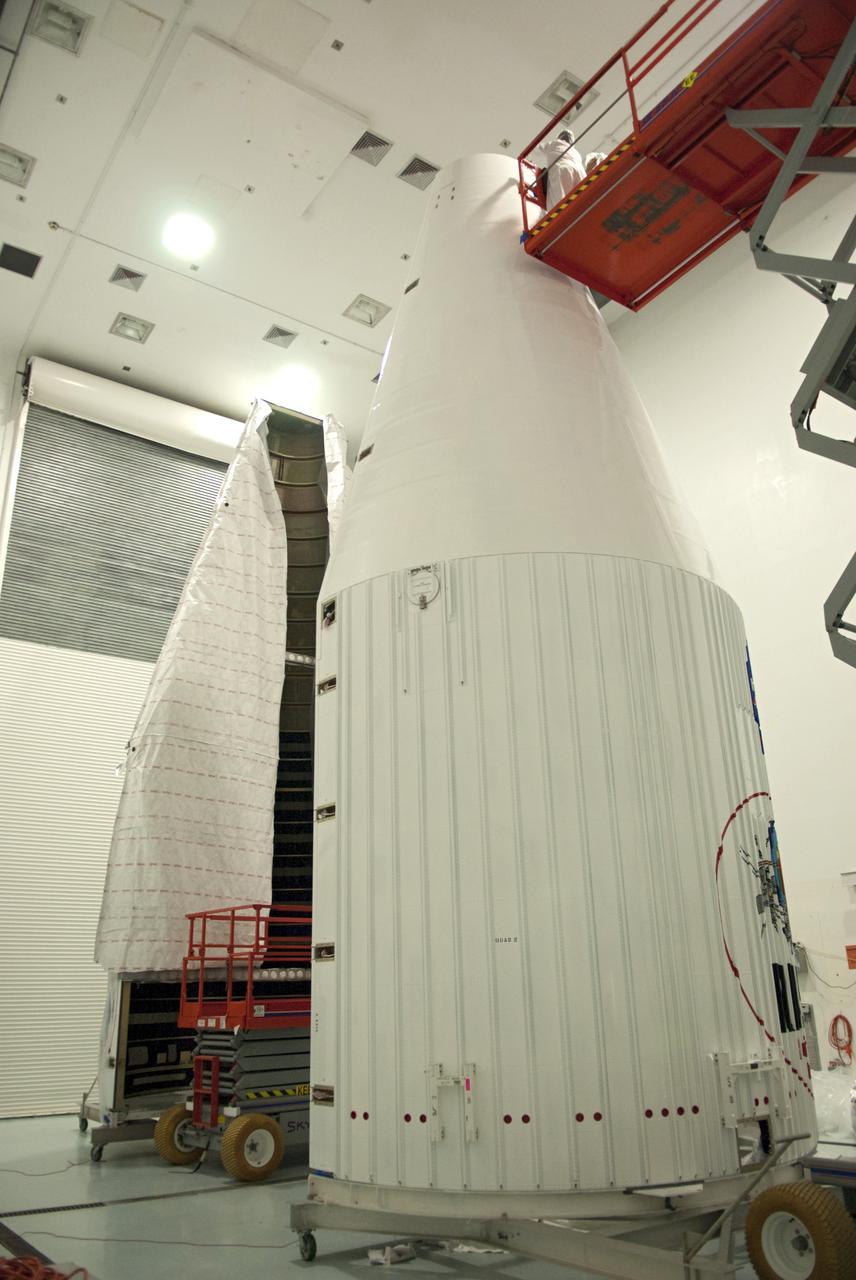 CAPE CANAVERAL, Fla. - Inside the Astrotech payload processing facility near NASA’s Kennedy Space Center in Florida, technicians use a lift to inspect and uncover the nose cone fairing for the Radiation Belt Storm Probes, or RBSP, spacecraft. The nose faring will house and protect the RBSP during liftoff aboard an Atlas V rocket. NASA’s RBSP mission will help us understand the sun’s influence on Earth and near-Earth space by studying the Earth’s radiation belts on various scales of space and time. RBSP will begin its mission of exploration of Earth’s Van Allen radiation belts and the extremes of space weather after its liftoff aboard a United Launch Alliance Atlas V from Space Launch Complex 41 at Cape Canaveral Air Force Station, Fla. Liftoff is targeted for Aug. 23, 2012. For more information, visit http://www.nasa.gov/rbsp. Photo credit: NASA/Charisse Nahser