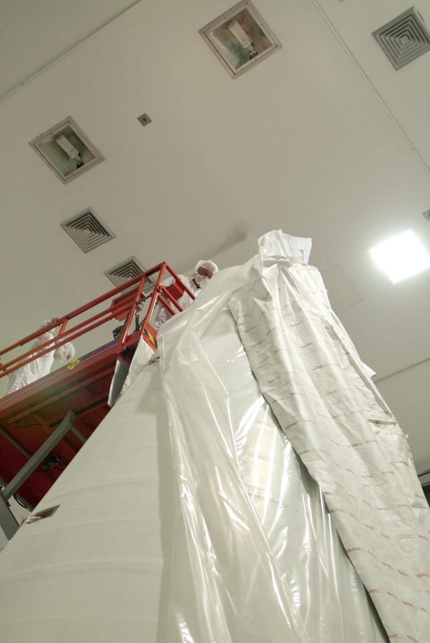 CAPE CANAVERAL, Fla. - Inside the Astrotech payload processing facility near NASA’s Kennedy Space Center in Florida, technicians use a lift to uncover and inspect the nose cone fairing for the Radiation Belt Storm Probes, or RBSP, spacecraft. The nose faring will house and protect the RBSP during liftoff aboard an Atlas V rocket.rocket. NASA’s RBSP mission will help us understand the sun’s influence on Earth and near-Earth space by studying the Earth’s radiation belts on various scales of space and time. RBSP will begin its mission of exploration of Earth’s Van Allen radiation belts and the extremes of space weather after its liftoff aboard a United Launch Alliance Atlas V from Space Launch Complex 41 at Cape Canaveral Air Force Station, Fla. Liftoff is targeted for Aug. 23, 2012. For more information, visit http://www.nasa.gov/rbsp. Photo credit: NASA/Charisse Nahser