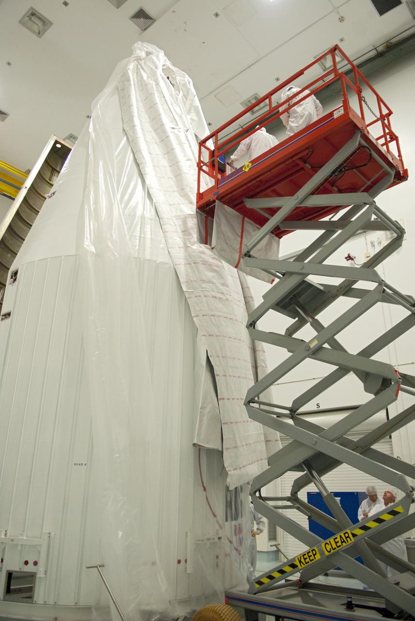CAPE CANAVERAL, Fla. - Inside the Astrotech payload processing facility near NASA’s Kennedy Space Center in Florida, technicians use a lift to uncover and inspect the nose cone fairing for the Radiation Belt Storm Probes, or RBSP, spacecraft. The nose faring will house and protect the RBSP during liftoff aboard an Atlas V rocket. NASA’s RBSP mission will help us understand the sun’s influence on Earth and near-Earth space by studying the Earth’s radiation belts on various scales of space and time. RBSP will begin its mission of exploration of Earth’s Van Allen radiation belts and the extremes of space weather after its liftoff aboard a United Launch Alliance Atlas V from Space Launch Complex 41 at Cape Canaveral Air Force Station, Fla. Liftoff is targeted for Aug. 23, 2012. For more information, visit http://www.nasa.gov/rbsp. Photo credit: NASA/Charisse Nahser