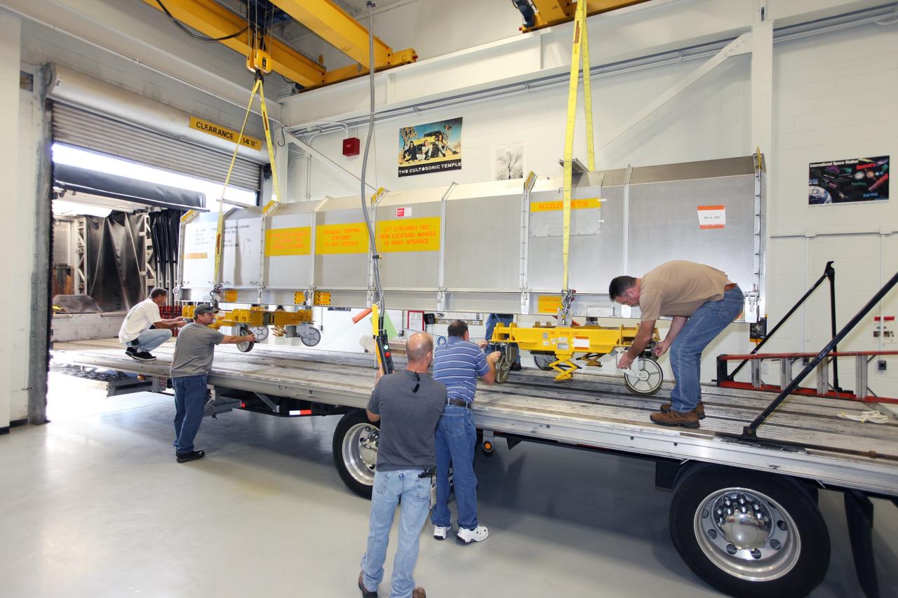 CAPE CANAVERAL, Fla. - Inside the Vehicle Assembly Building at NASA’s Kennedy Space Center in Florida, United Space Alliance workers help guide the container holding the remote manipulator system, or RMS, onto a flatbed truck for shipment back to the Canadian Space Agency. The RMS, also called the Canadarm, was manufactured for NASA’s Space Shuttle Program by SPAR Aerospace Ltd., which later became a part of MD Robotics in Ontario, Canada. During shuttle missions, the RMS was attached in the payload bay. Mission specialists operated the arm to remove payloads from the payload bay and hand them off to the larger Canadarm 2 on the International Space Station. The shuttle arm also was used during astronaut spacewalks. Photo credit: NASA/Kim Shiflett